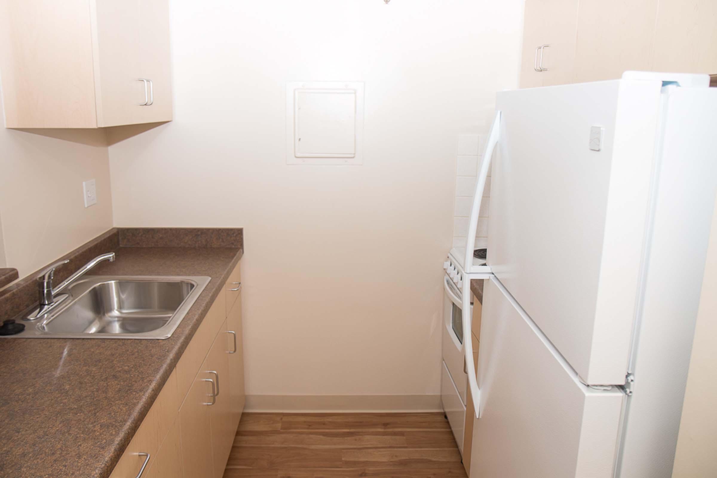 Kitchen with sink, refrigerator, and stove.