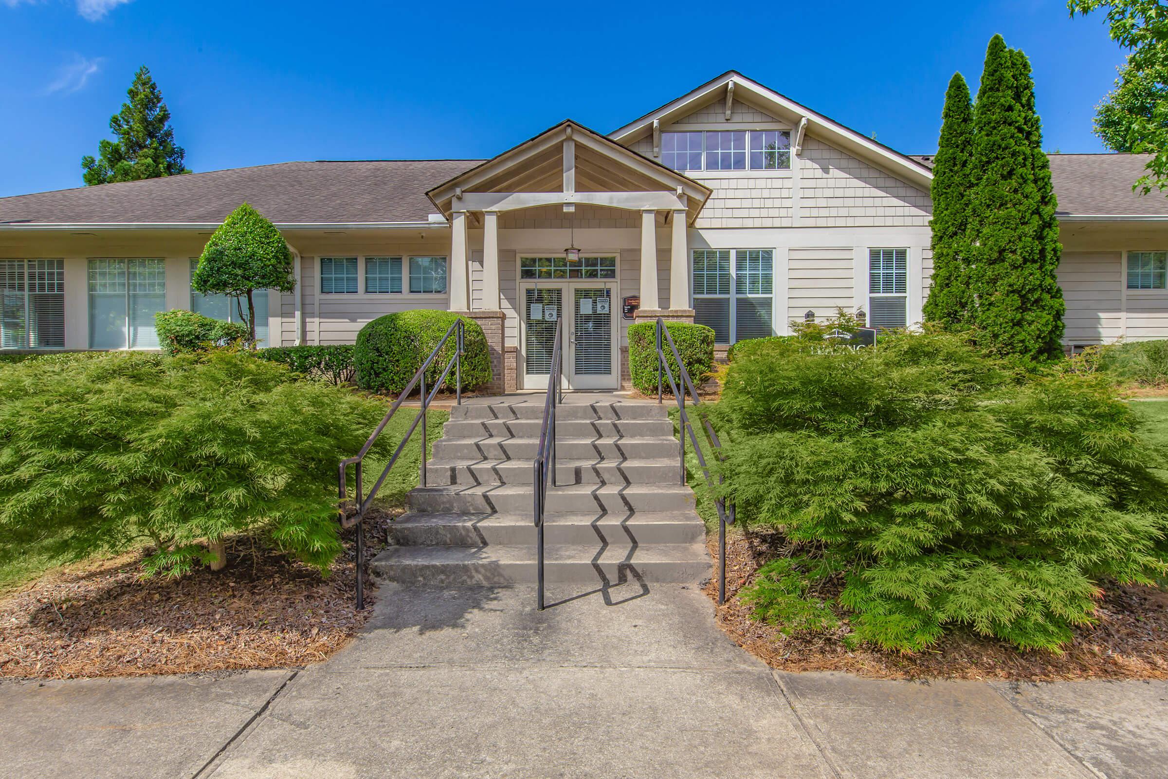 a house with bushes in front of a brick building