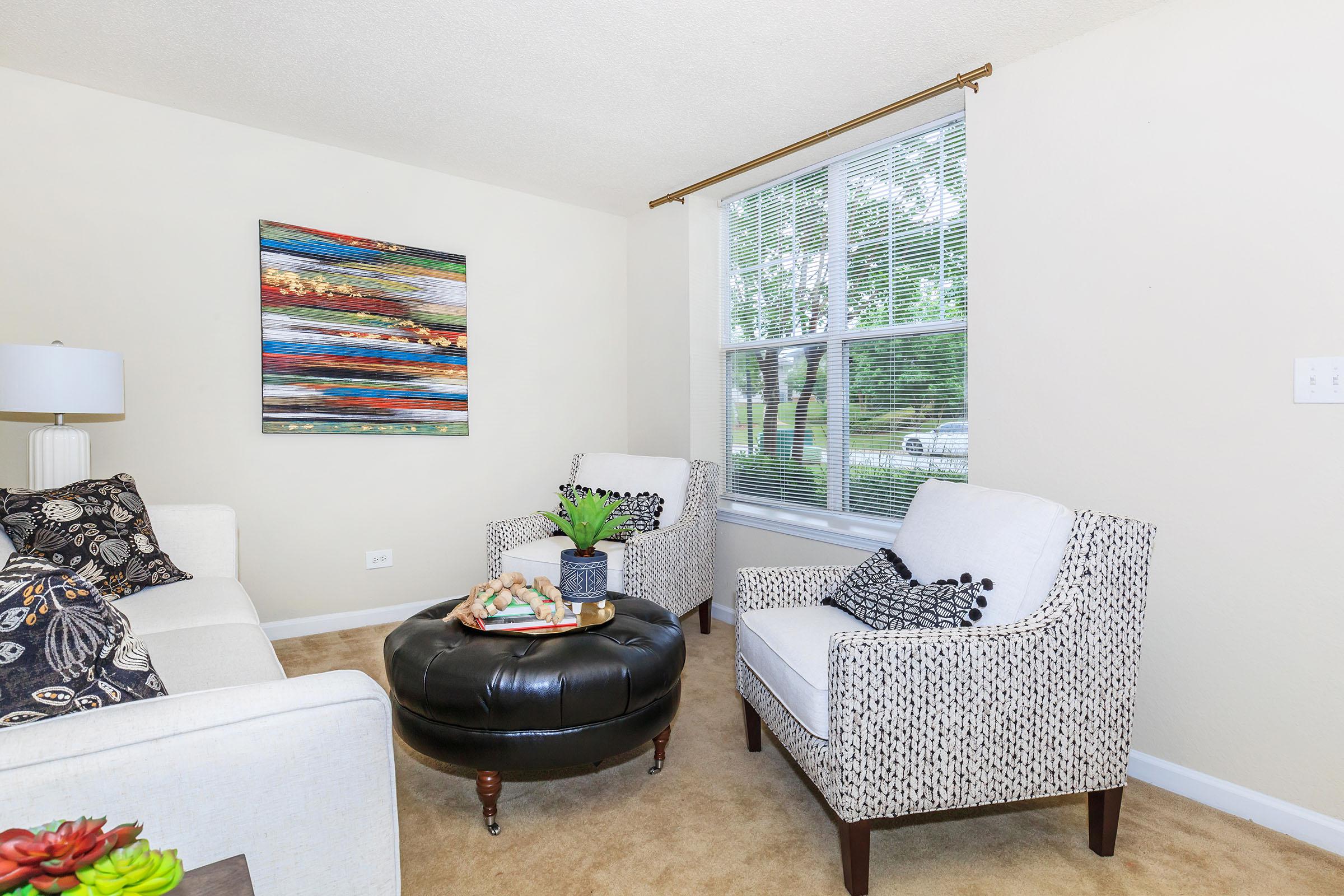 a living room filled with furniture and a large window