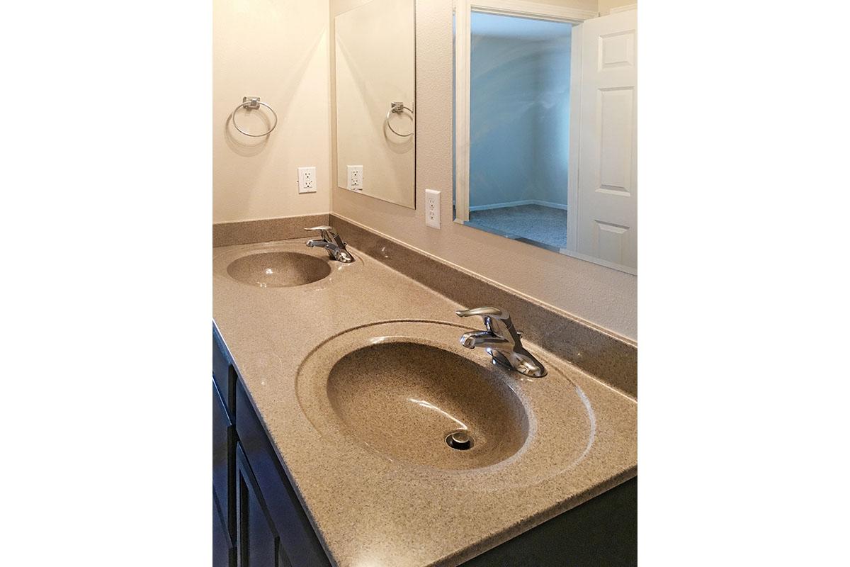 Two sinks with a tan countertop