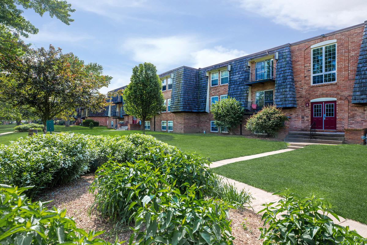 a house with bushes in front of a brick building