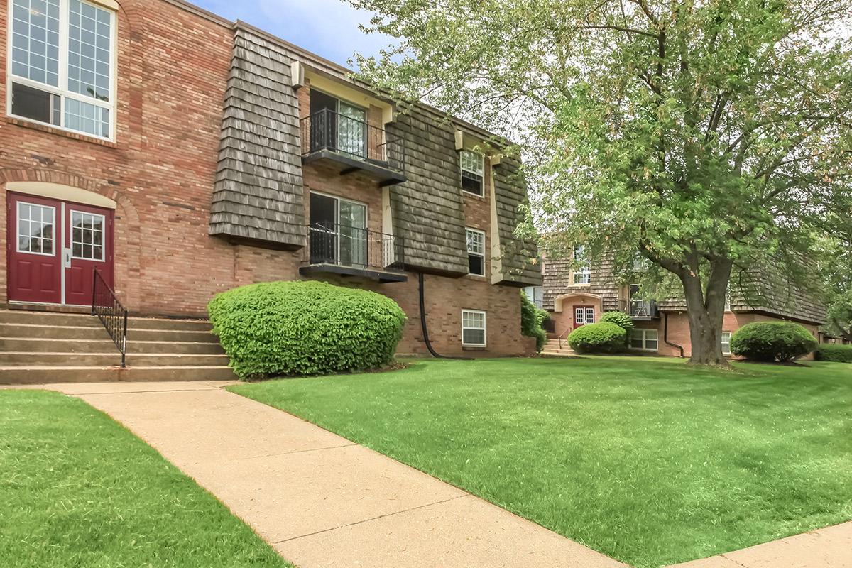 a large lawn in front of a brick building