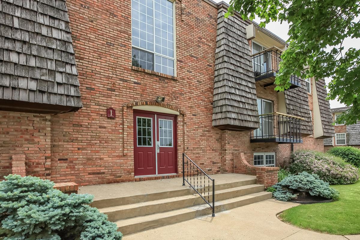 a house with bushes in front of a brick building