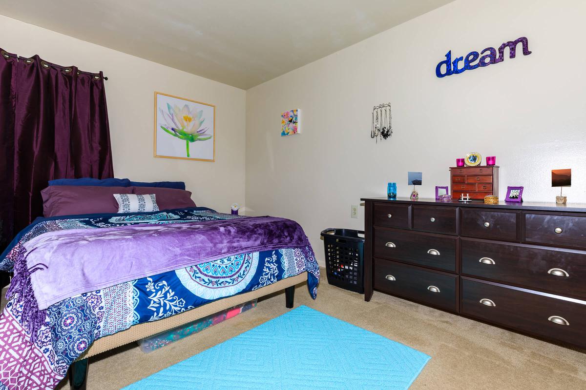 a bedroom with a bed and desk in a room