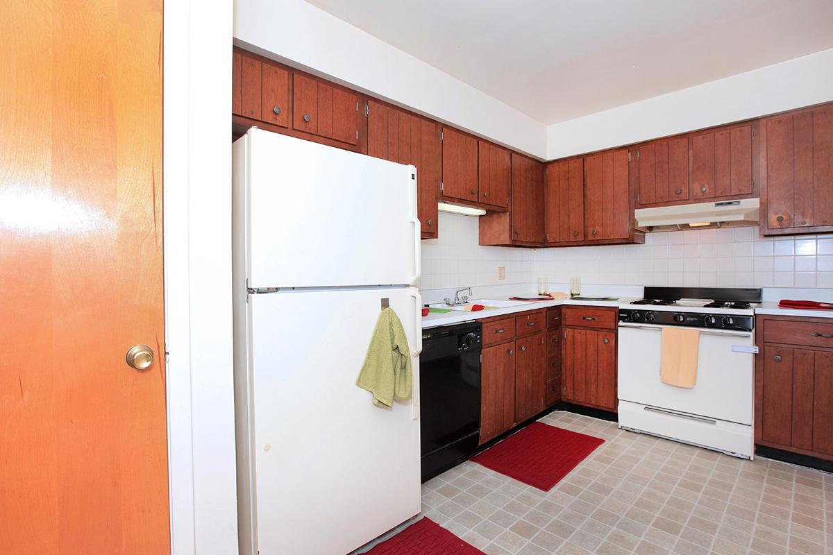 a kitchen with wooden cabinets and a wood floor