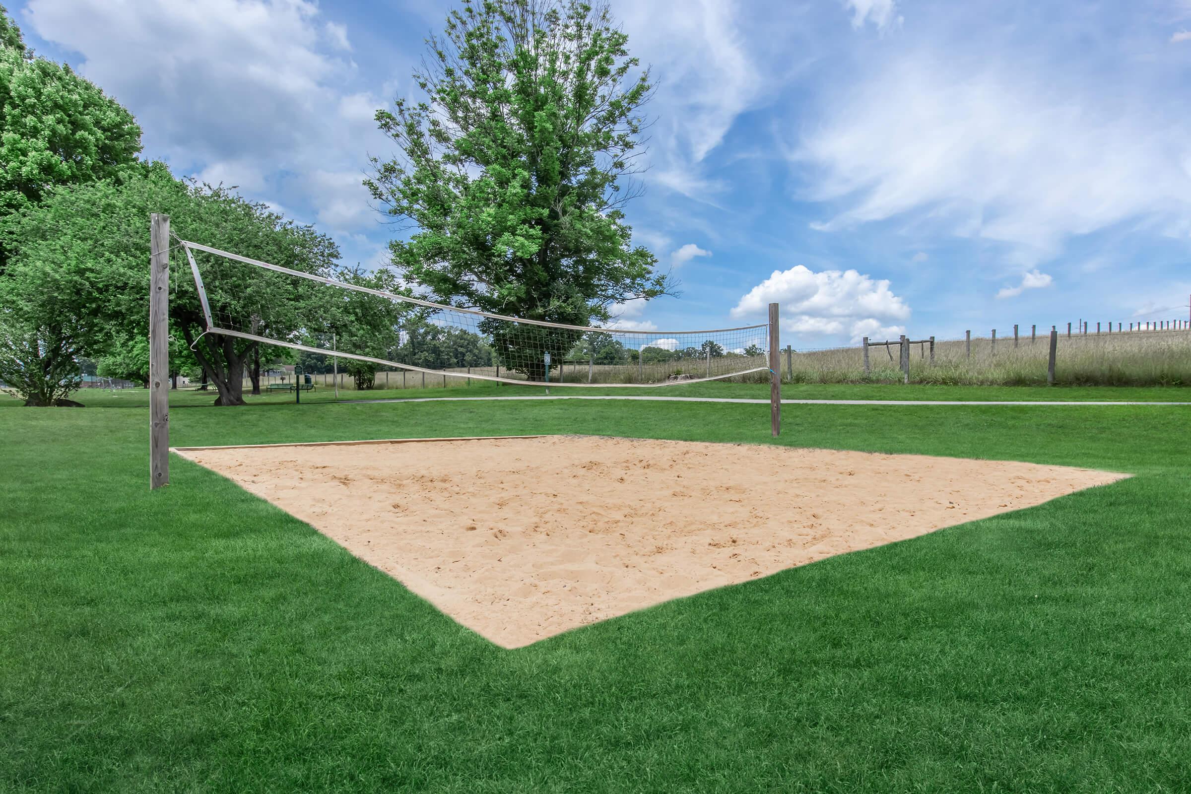 a large green field with trees in the background