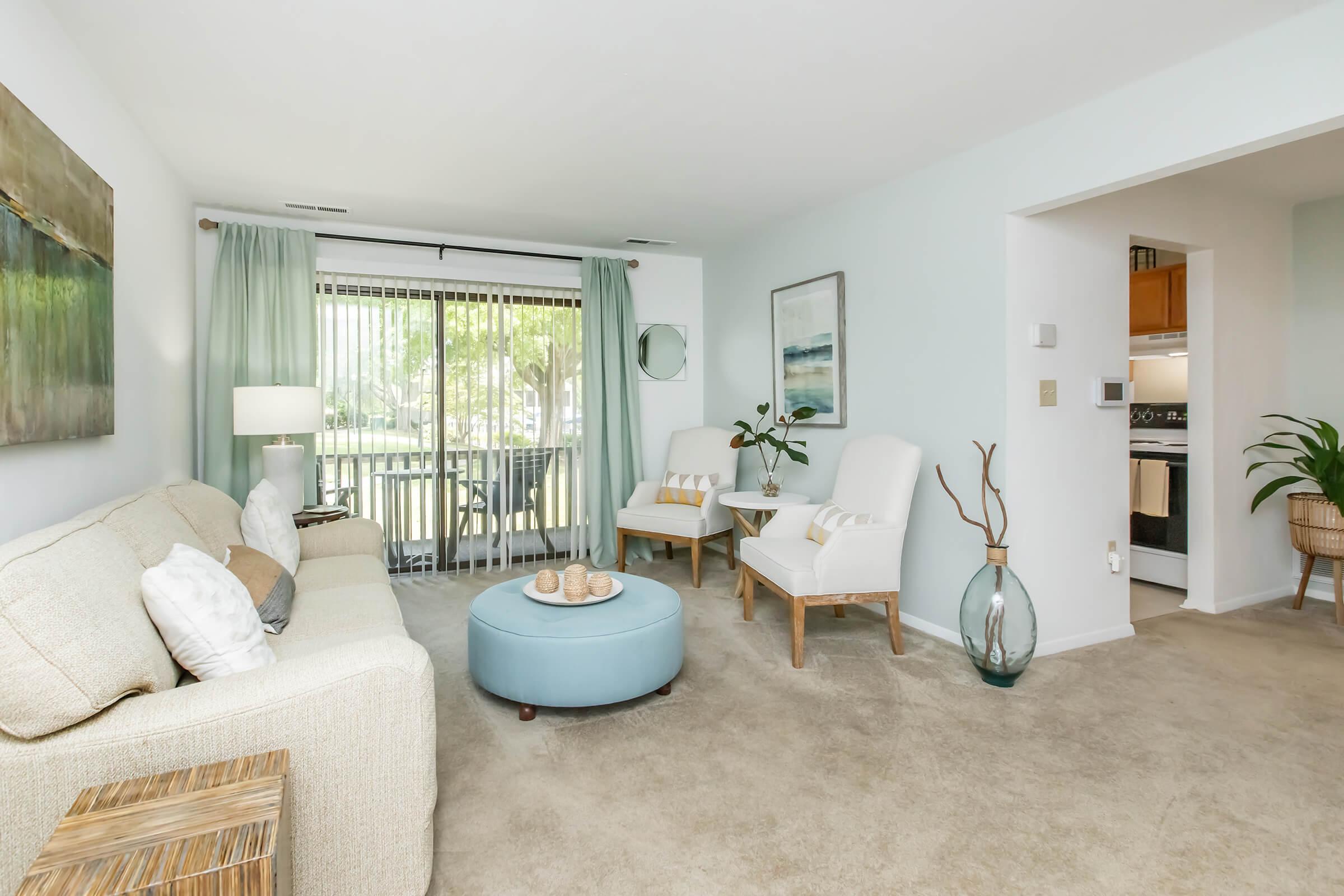 a living room filled with furniture and a large window