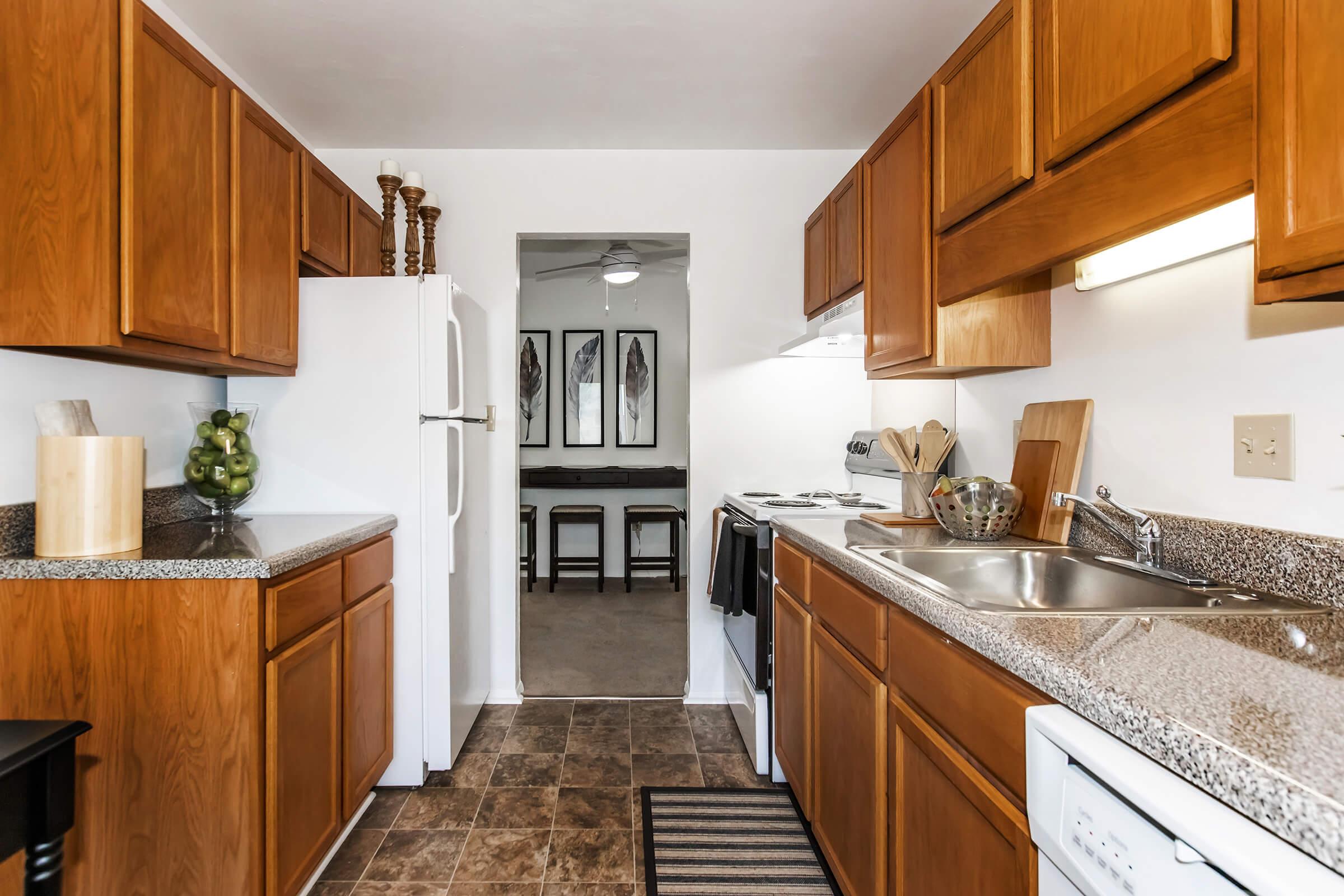 a large kitchen with stainless steel appliances and wooden cabinets