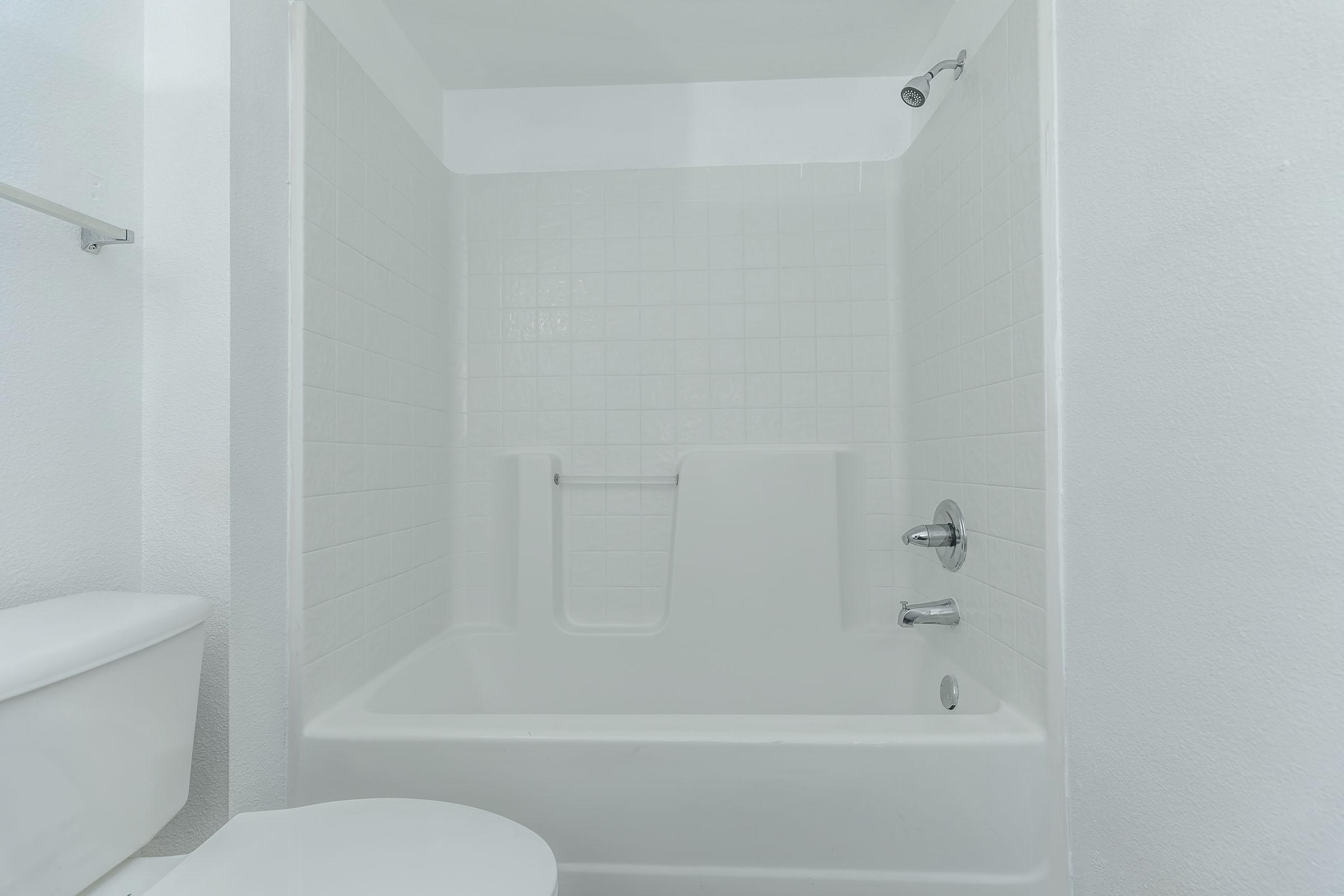 a room with a sink and a white tub sitting next to a shower