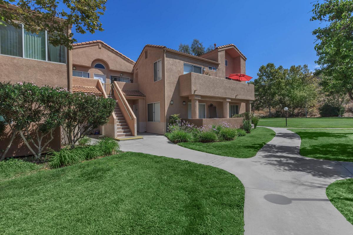 a house with a lawn in front of a brick building