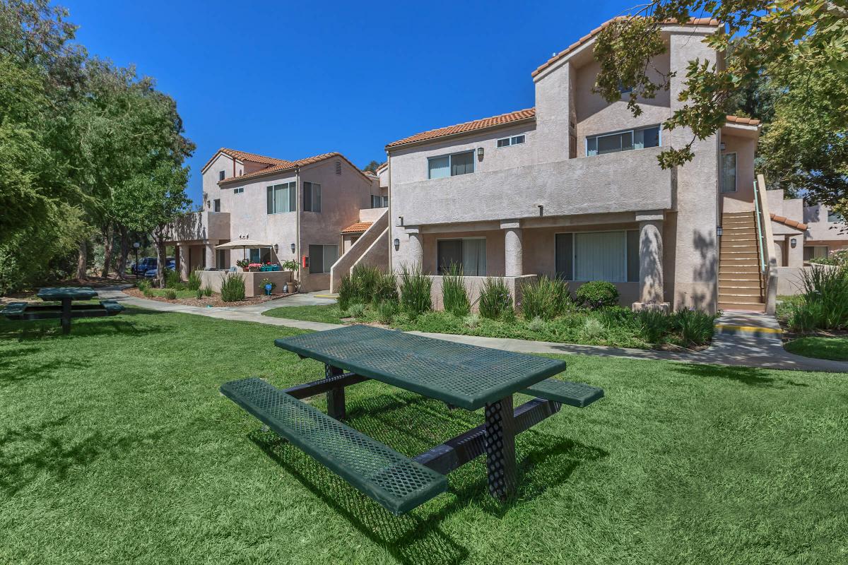 a couple of lawn chairs sitting on a bench in front of a house