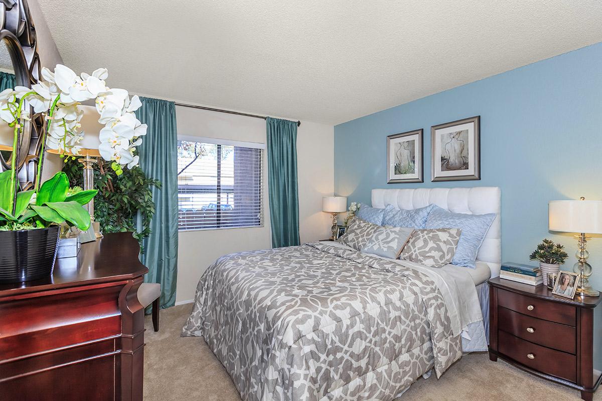 a bedroom with a bed and desk in a room