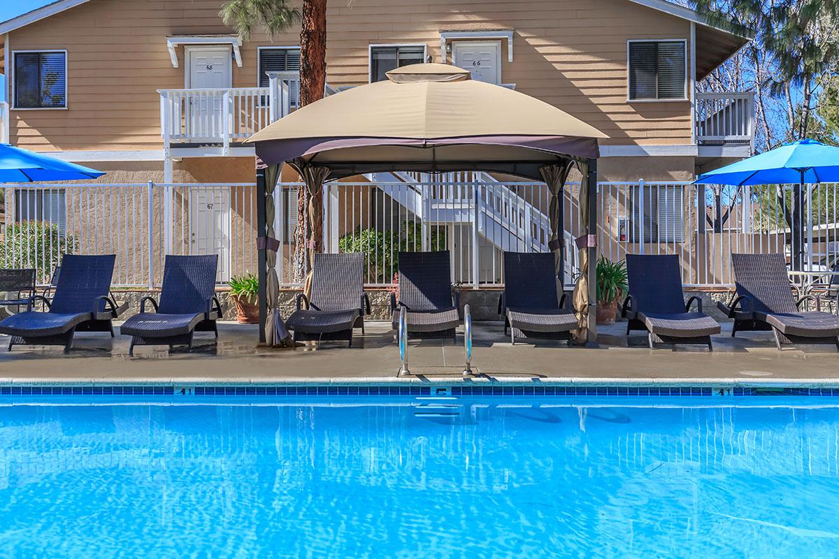 a group of lawn chairs sitting on top of a blue pool of water