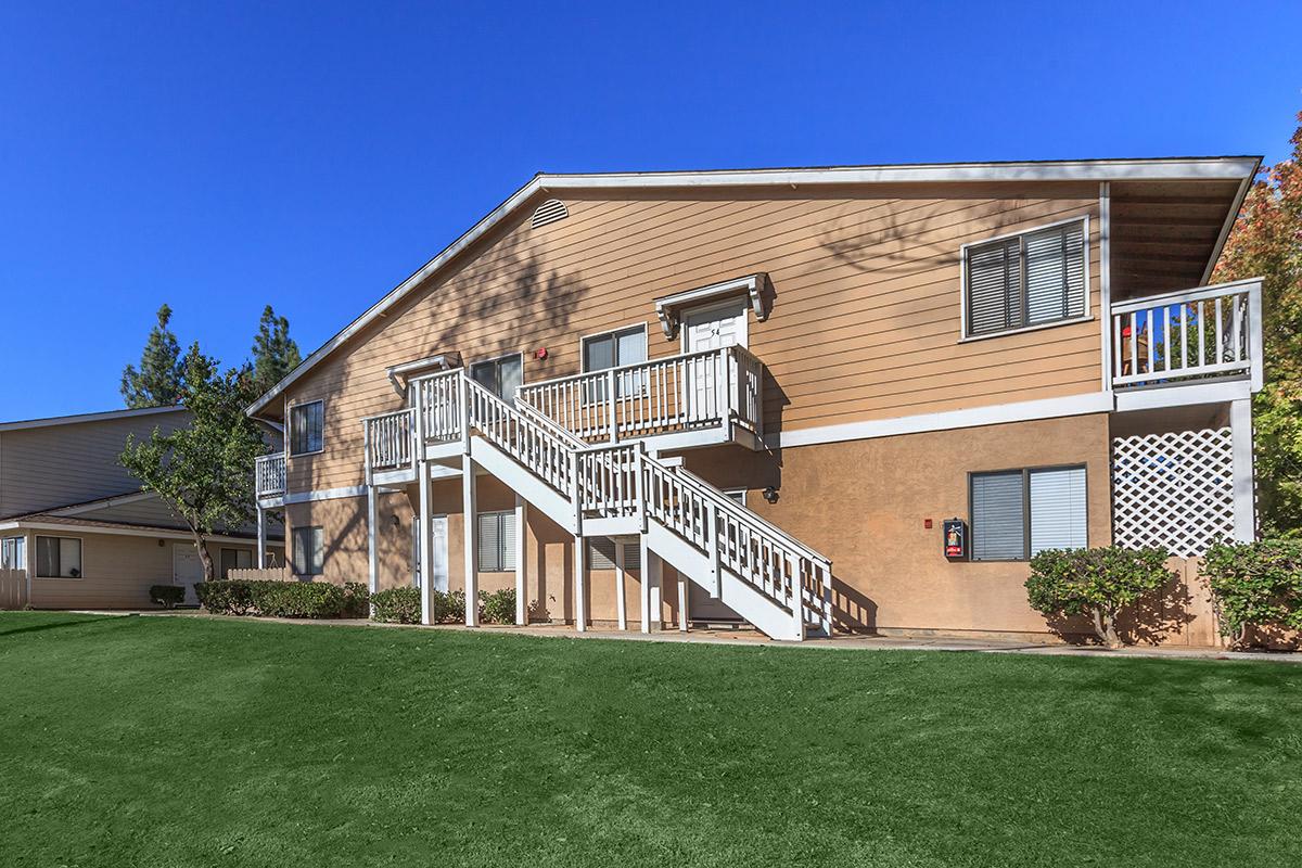 a large brick building with grass in front of a house