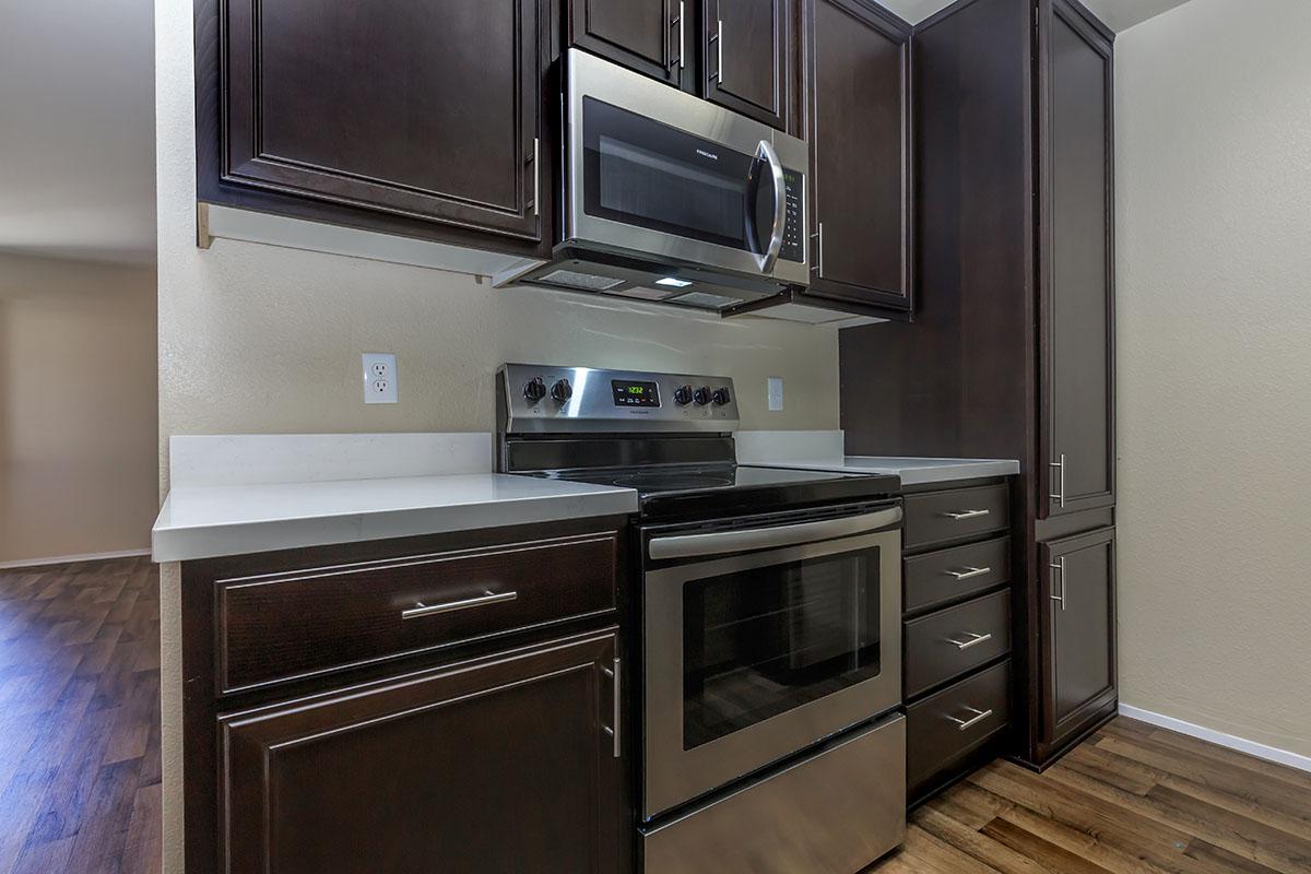 a stove top oven sitting inside of a kitchen with stainless steel appliances