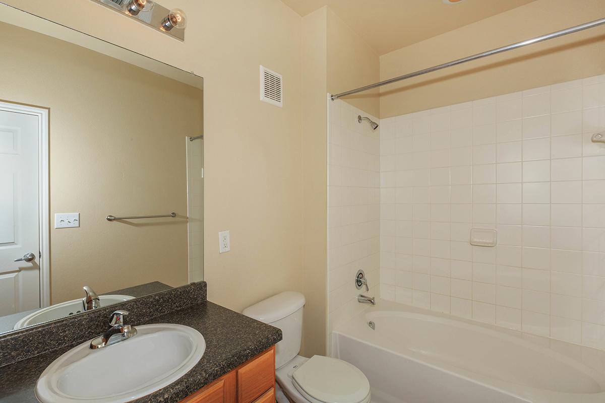 a white sink sitting under a mirror