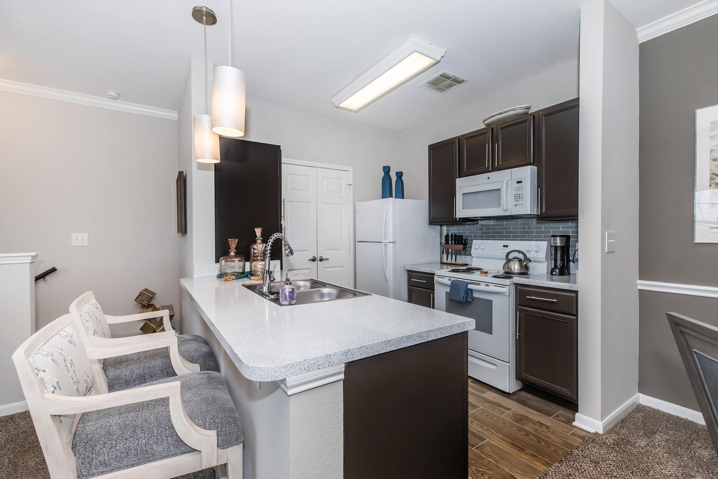 a kitchen with a sink and a mirror in a room