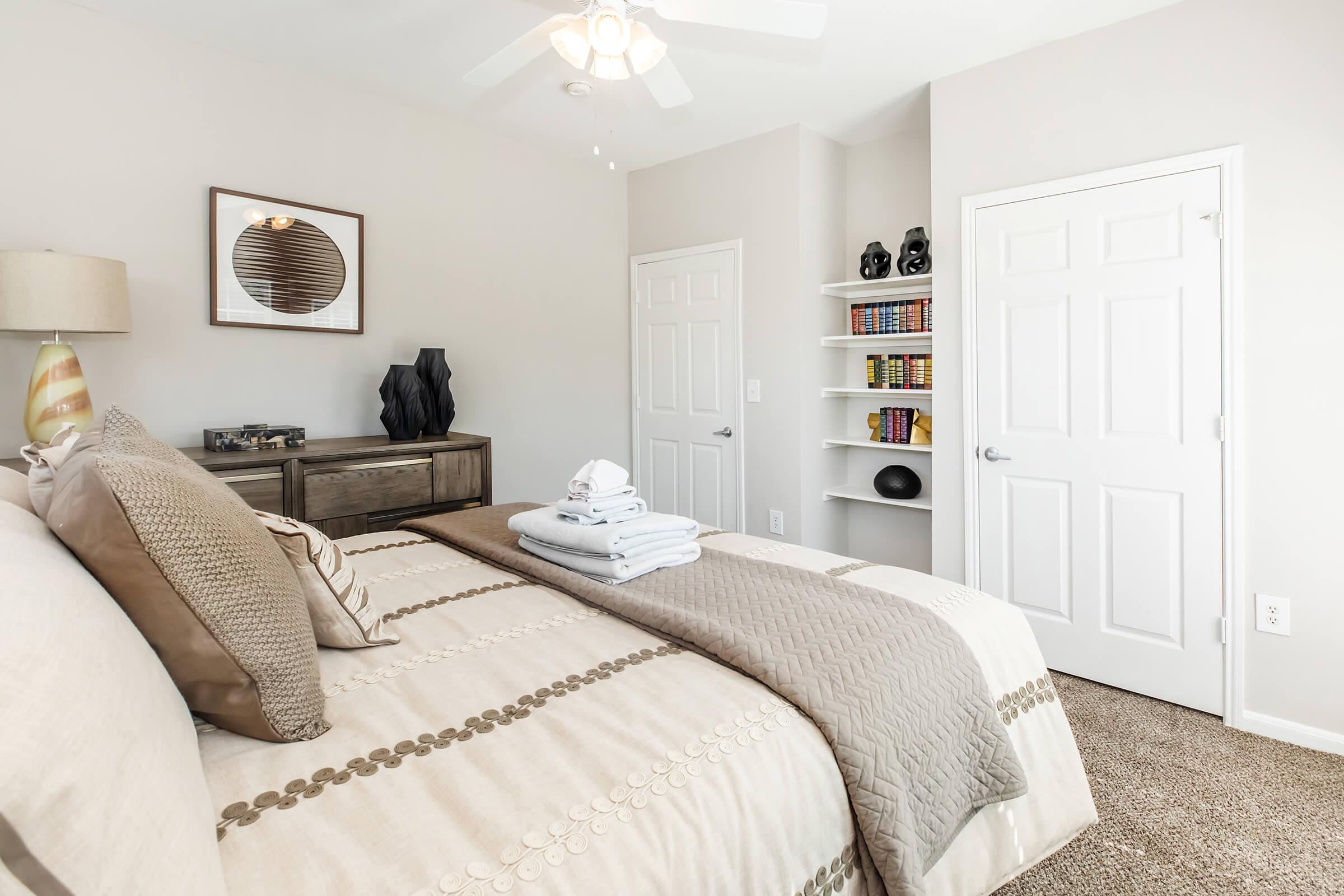 a bedroom with a bed and desk in a room