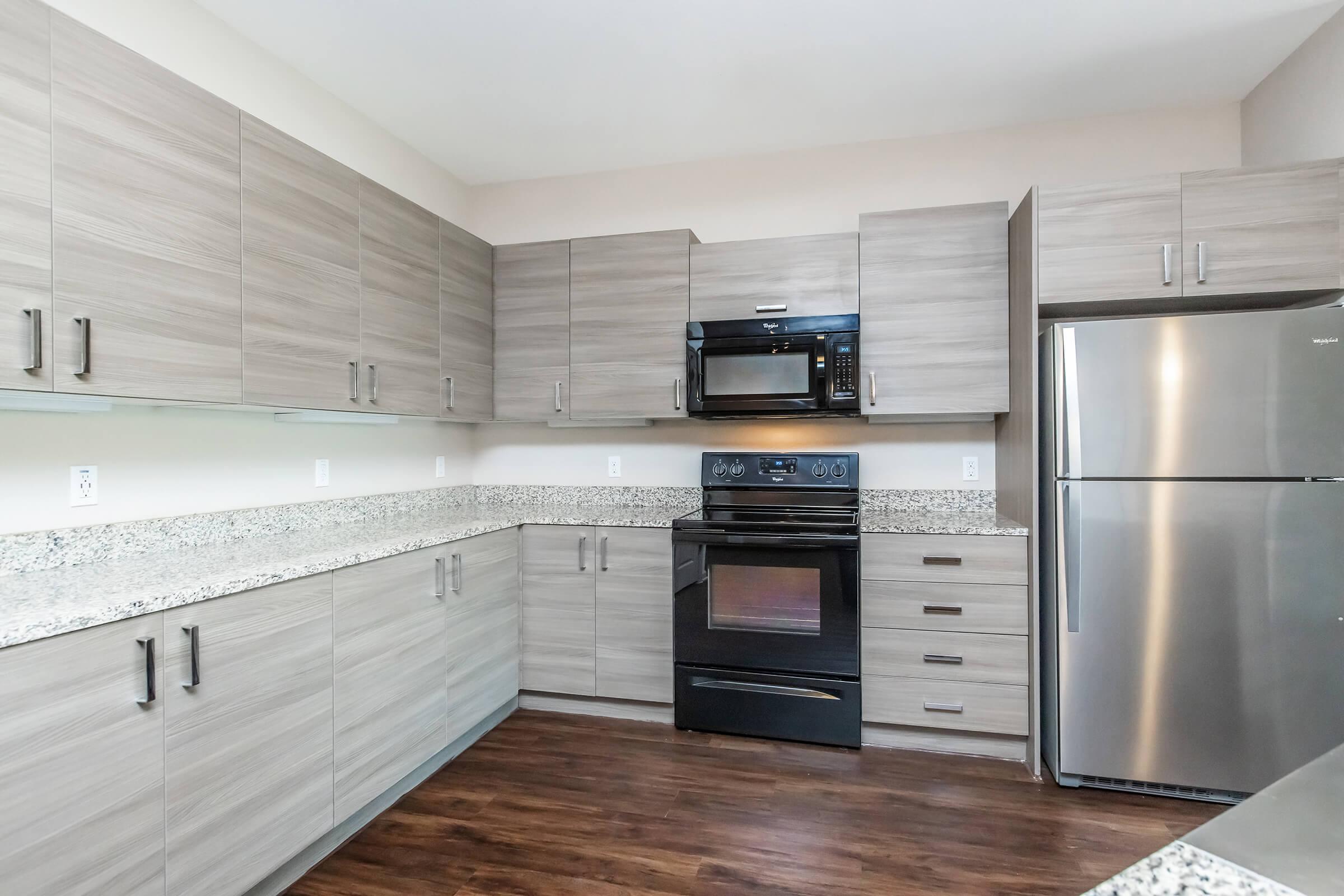 a large kitchen with stainless steel appliances and wooden cabinets