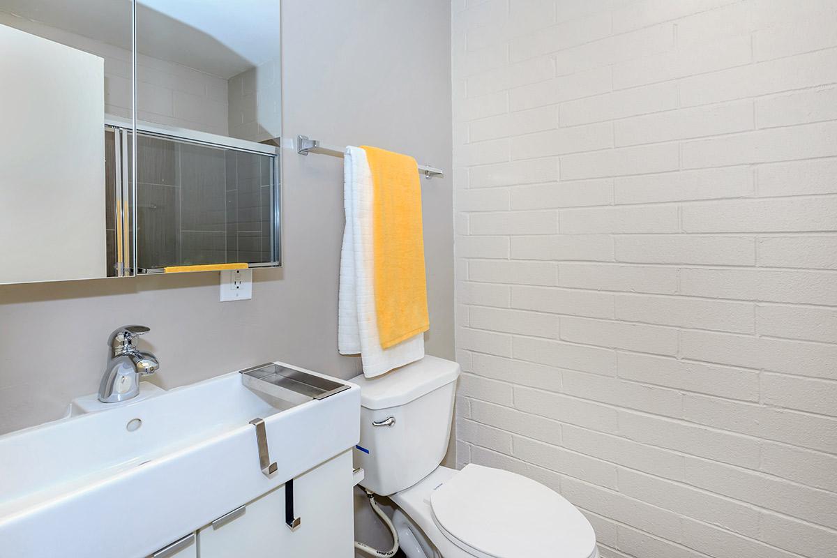 a white sink sitting under a mirror