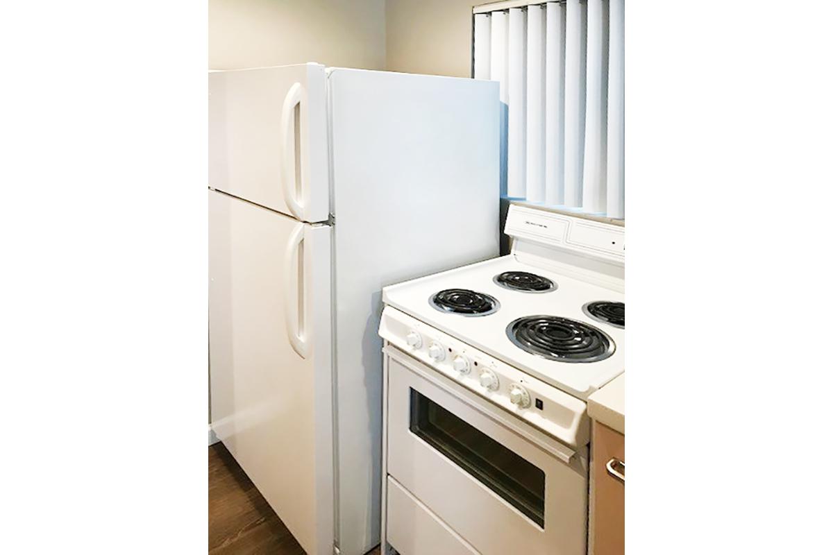 a white stove top oven sitting inside of a kitchen