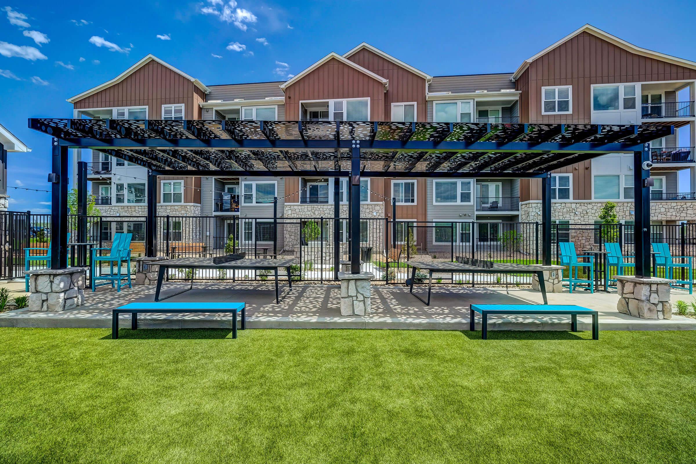 a group of lawn chairs sitting on a bench in front of a building