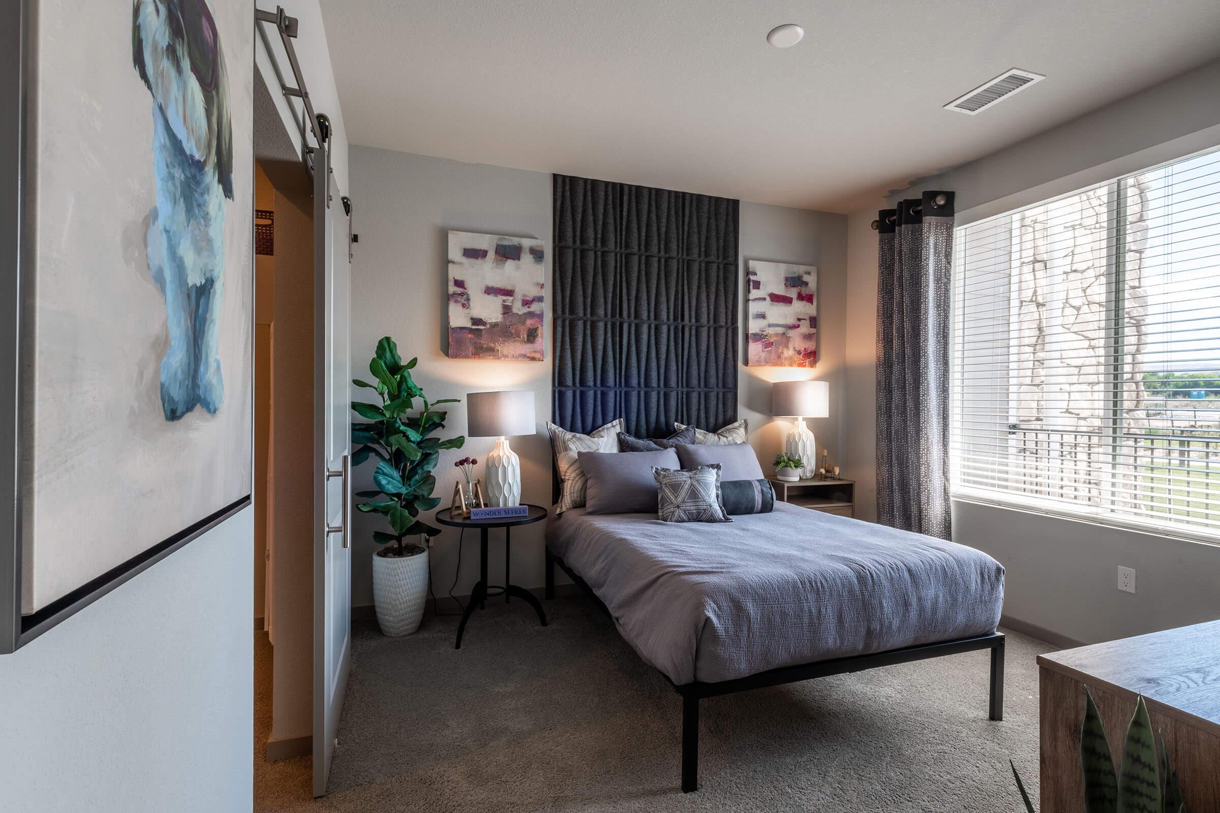 a bedroom with a bed and desk in a room