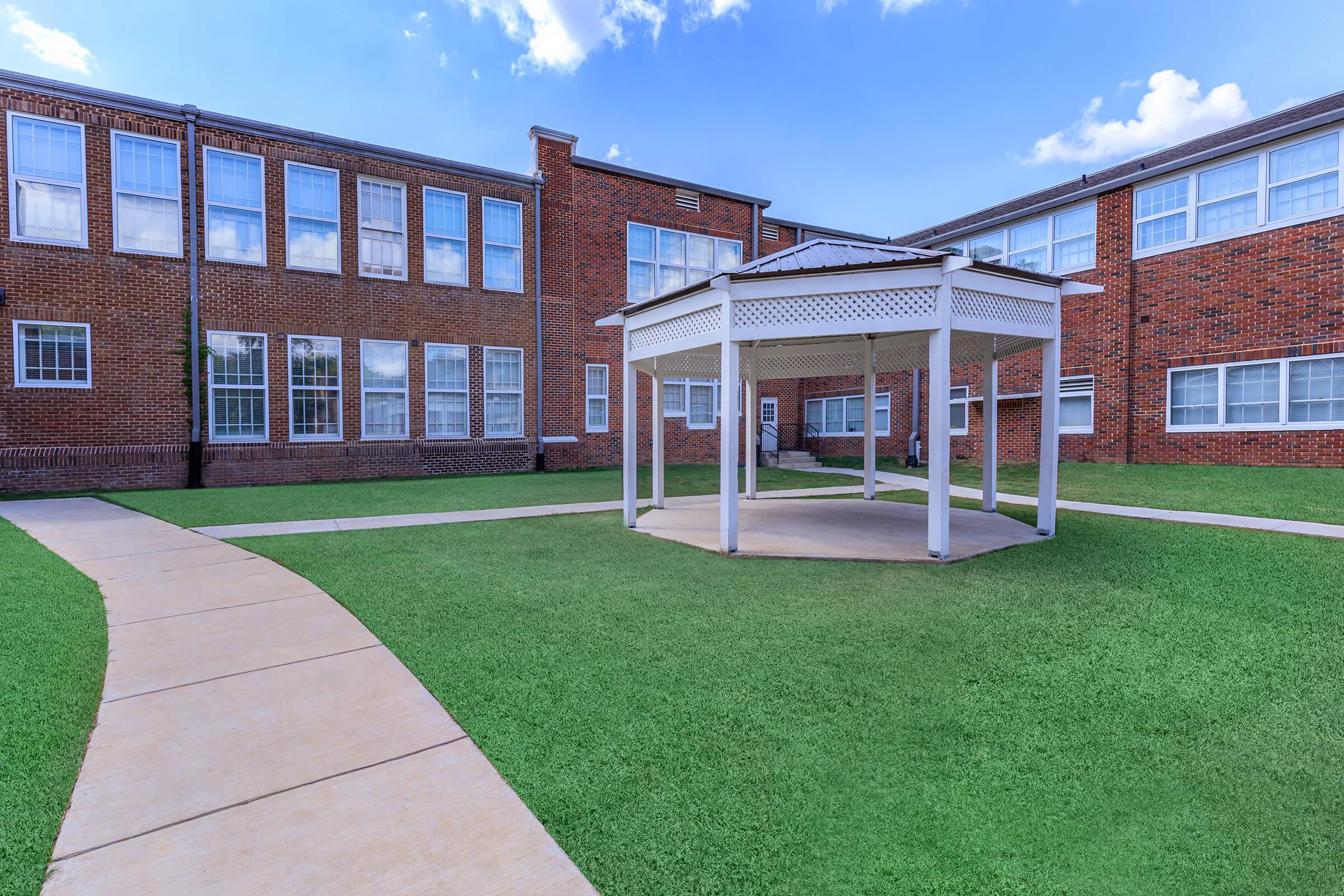 a large lawn in front of a brick building