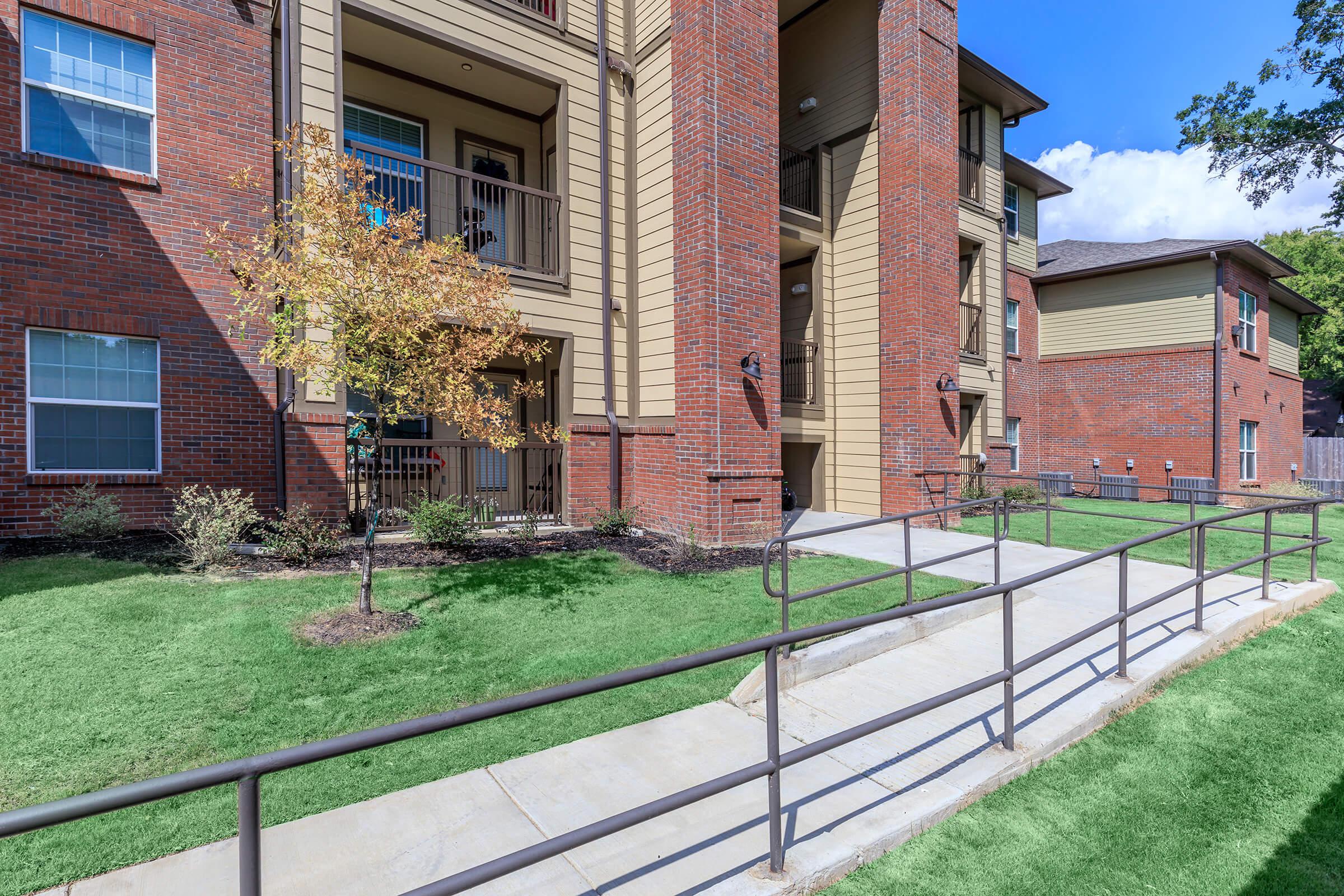 a house with a fence in front of a brick building