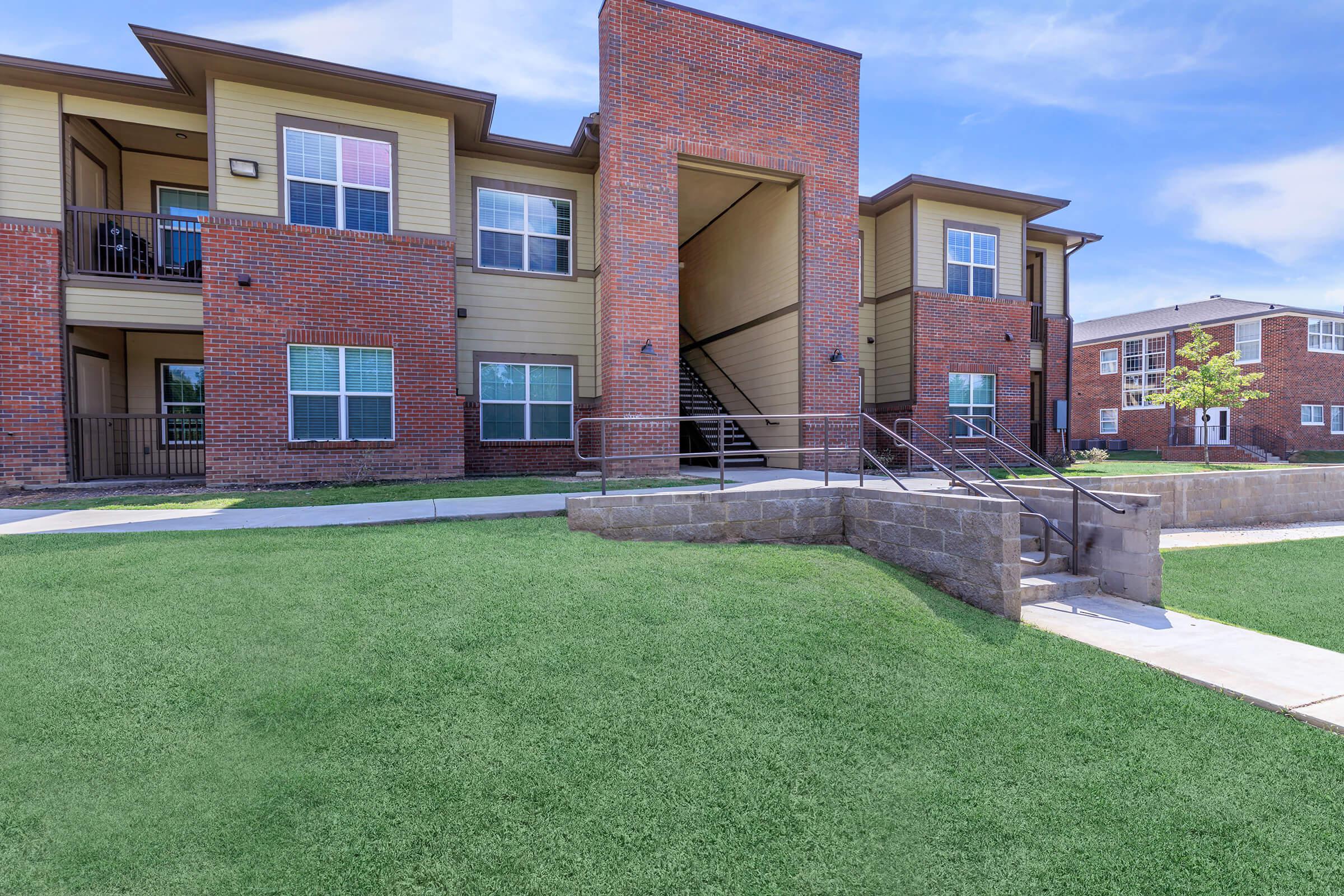 a large lawn in front of a brick building