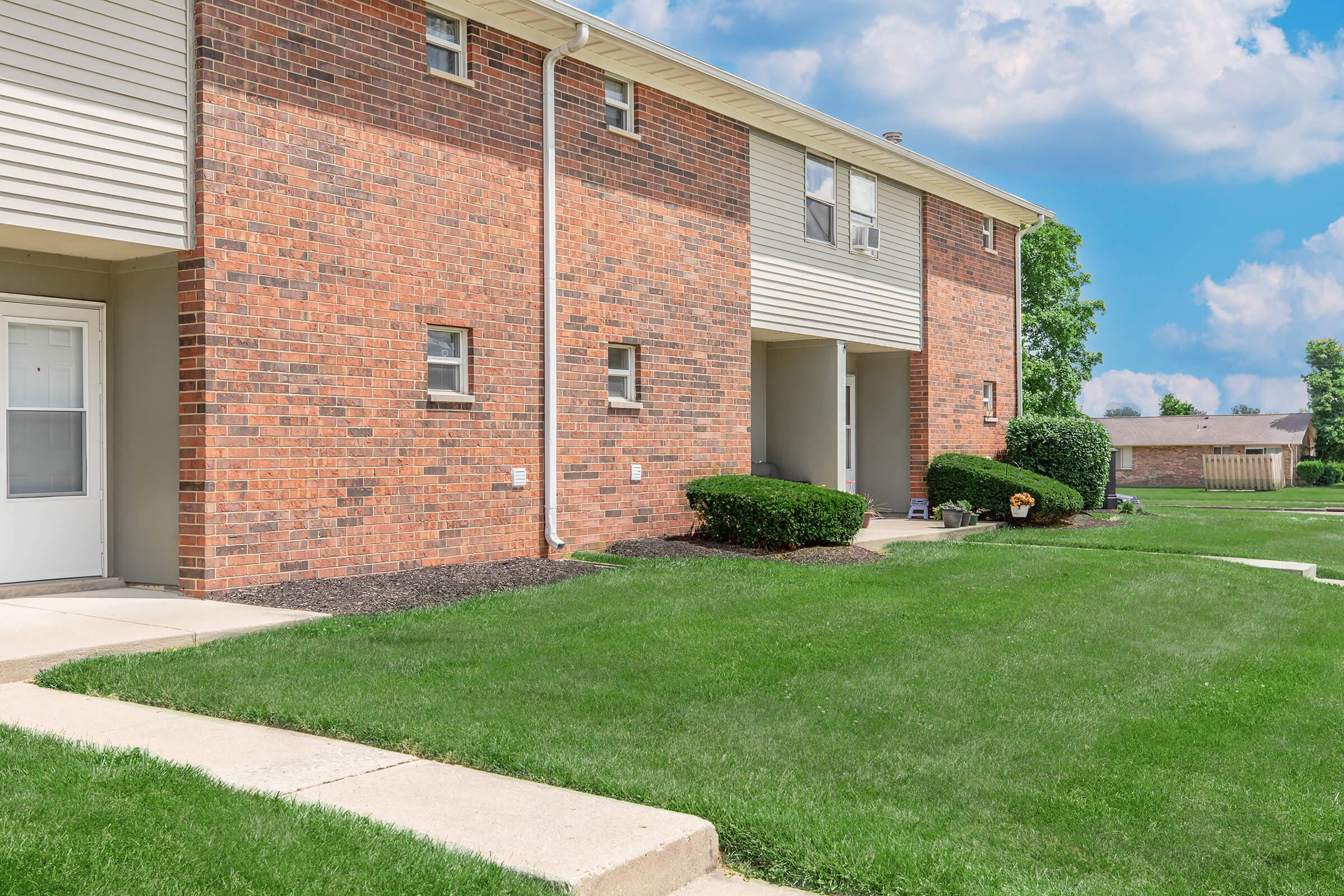 a large lawn in front of a brick building