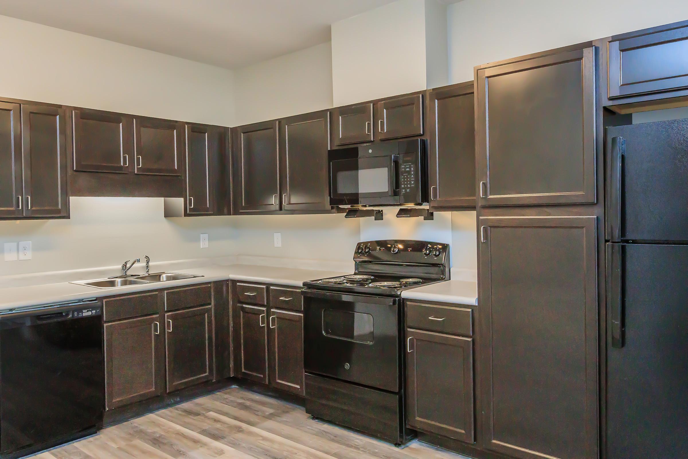 a large kitchen with stainless steel appliances and wooden cabinets