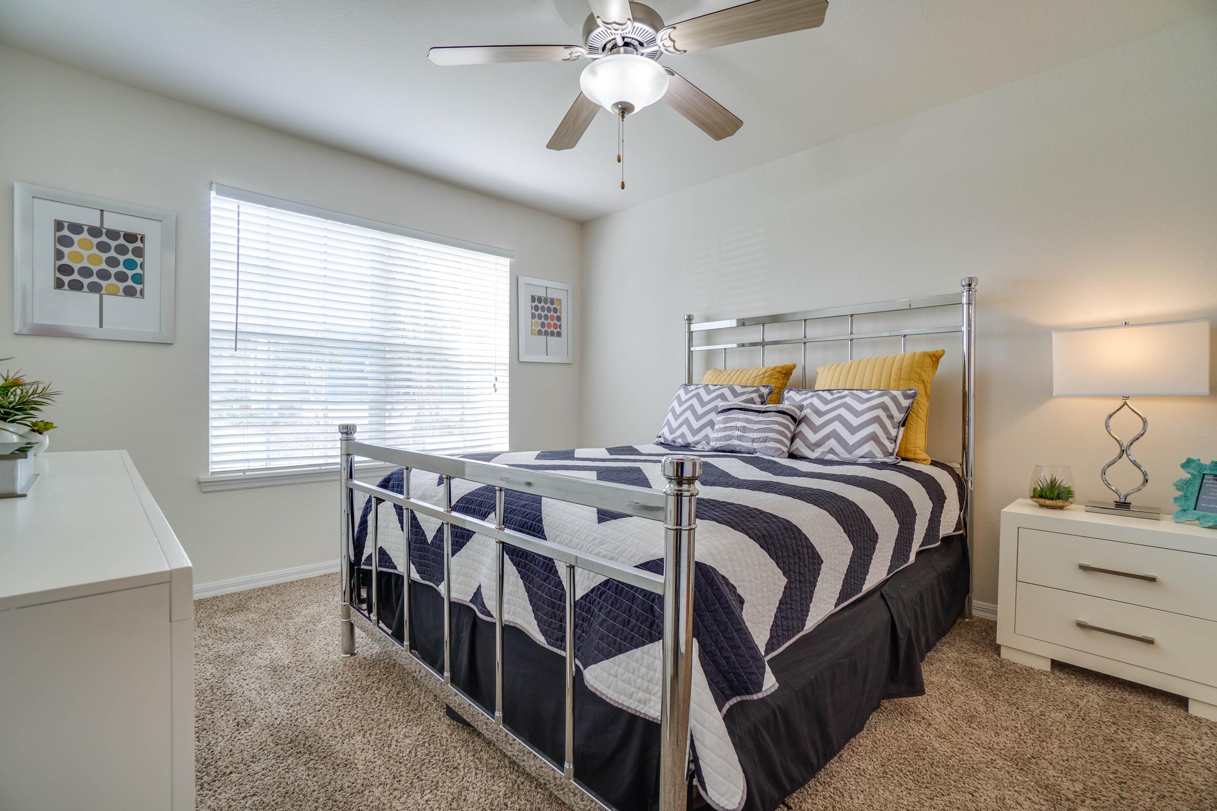 a bedroom with a bed and desk in a room