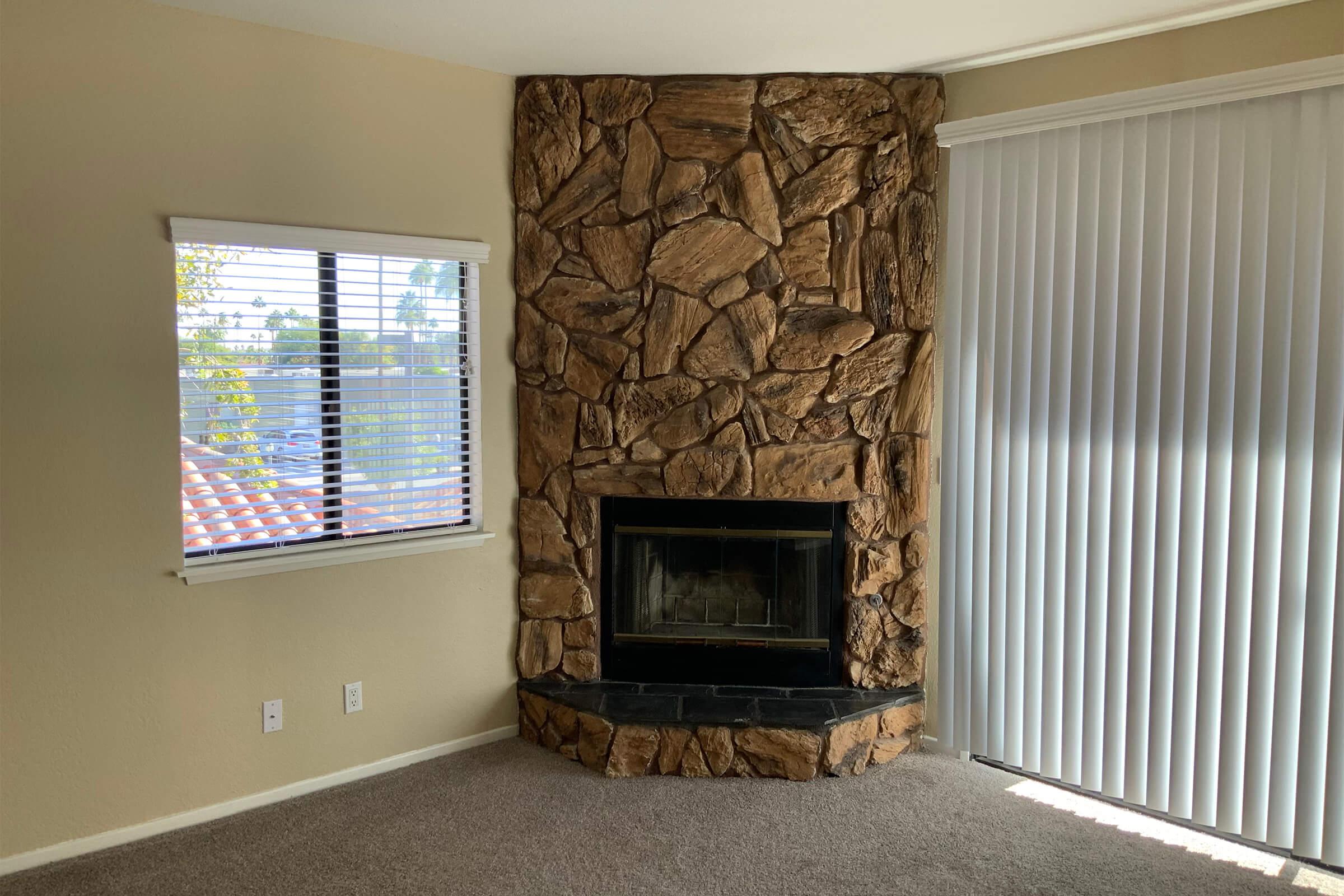 a living room with a fireplace and a large window