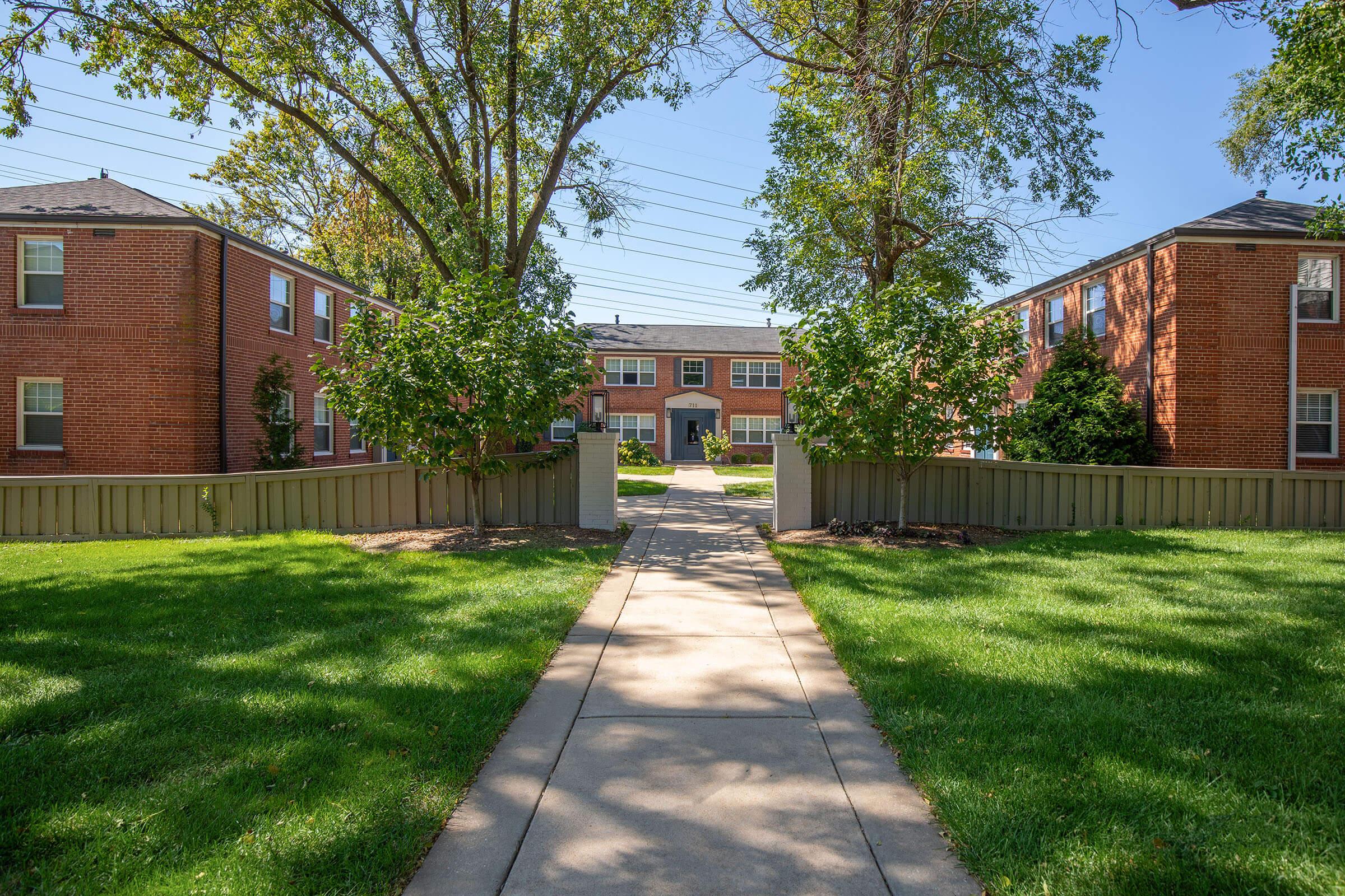 a house with a lawn in front of a brick building