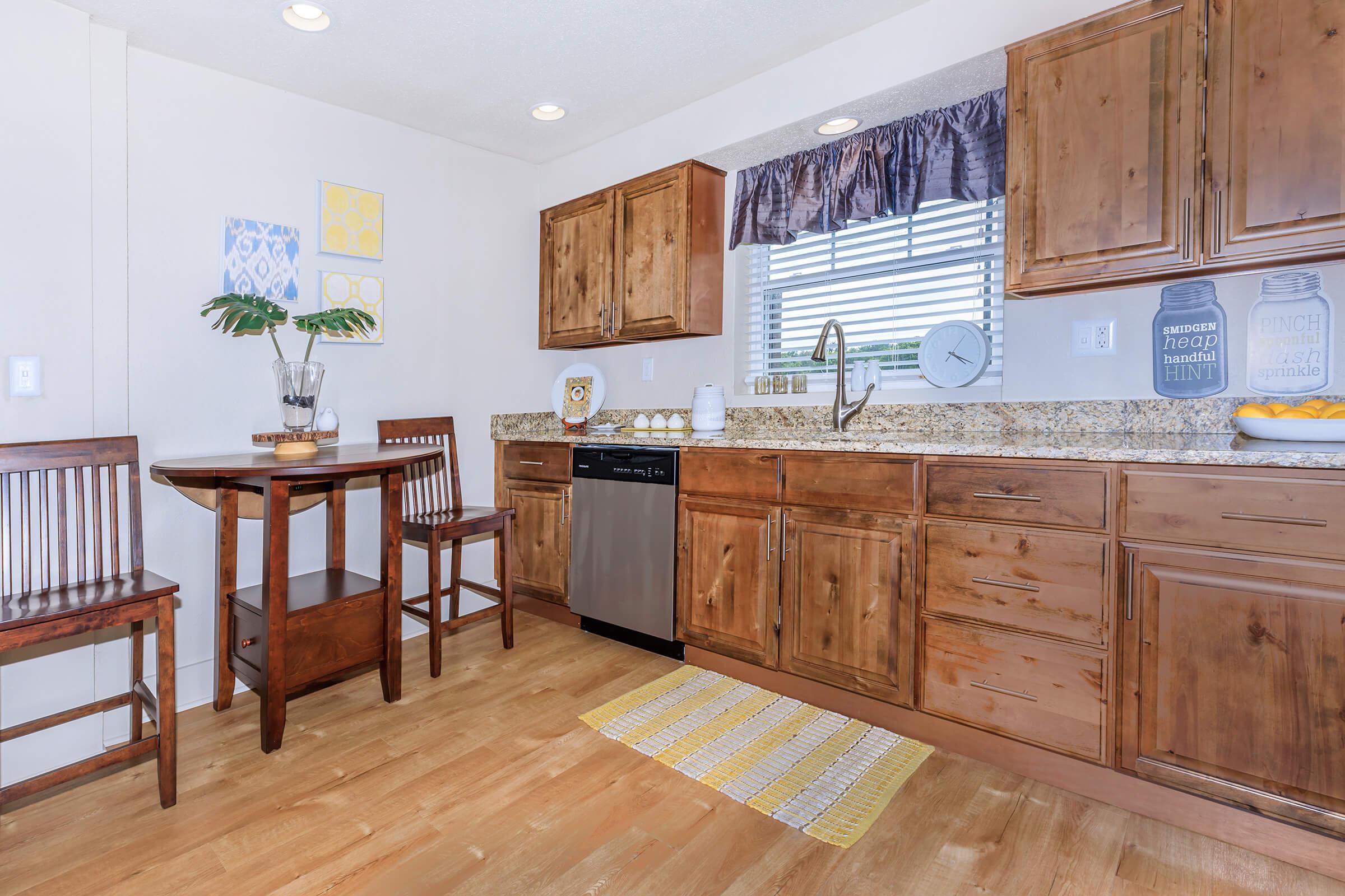 a kitchen with wooden cabinets and a wood floor