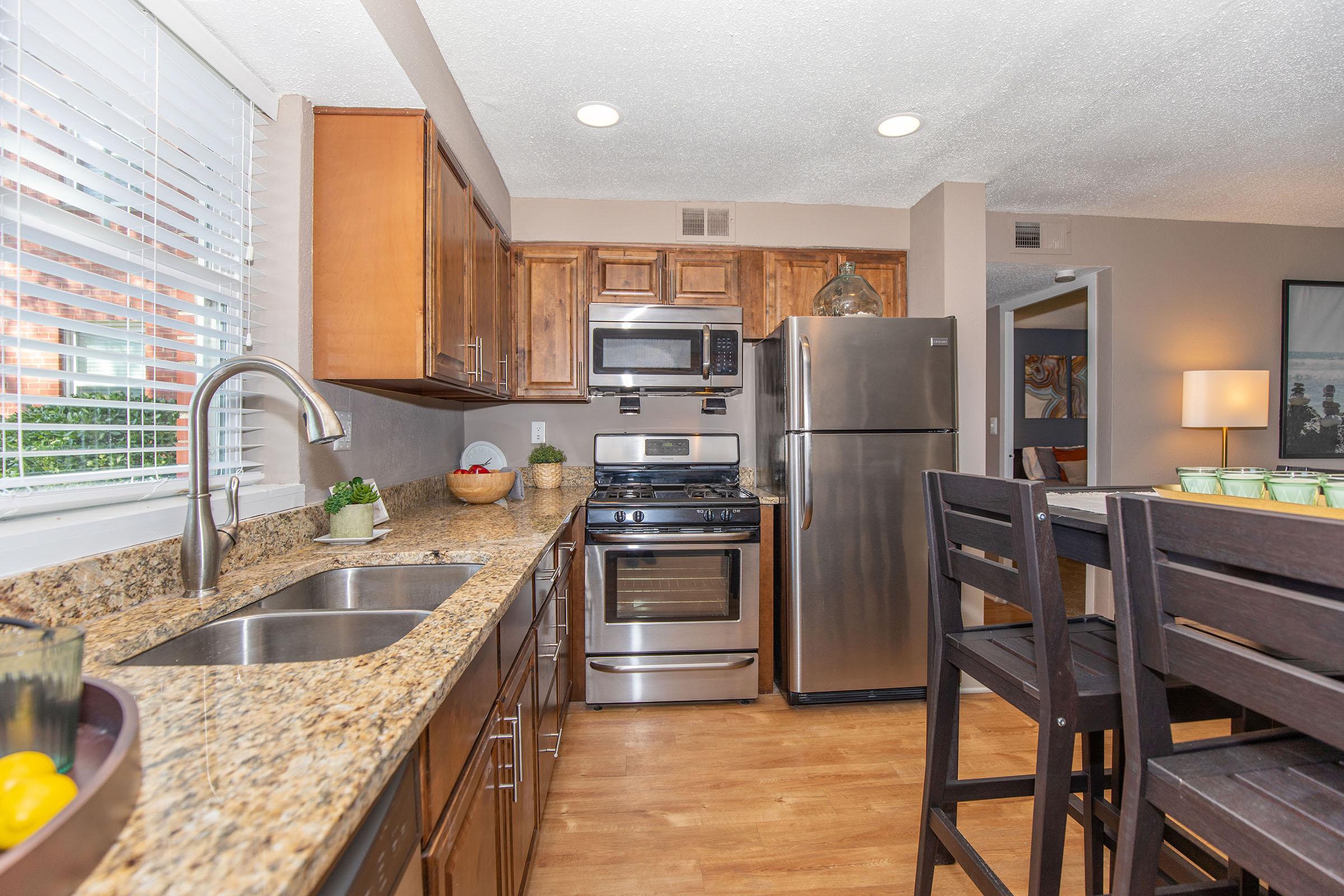 a modern kitchen with stainless steel appliances and wooden cabinets