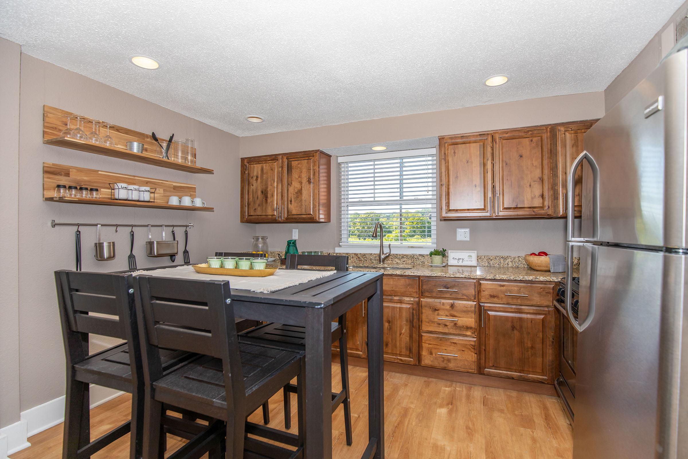 a kitchen with wooden cabinets and a dining room table