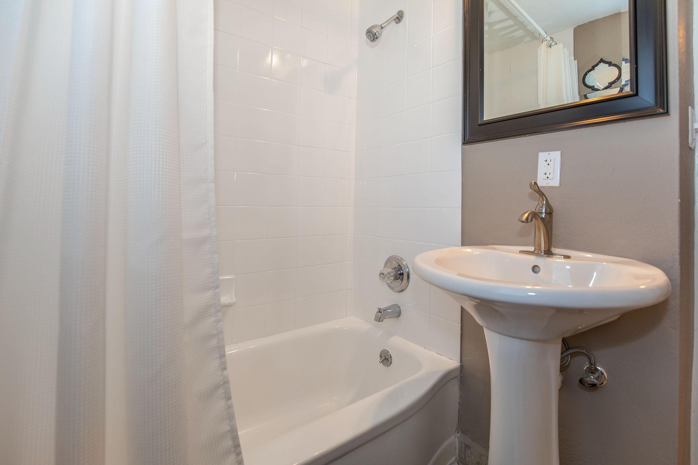 a shower that has a sink and a mirror