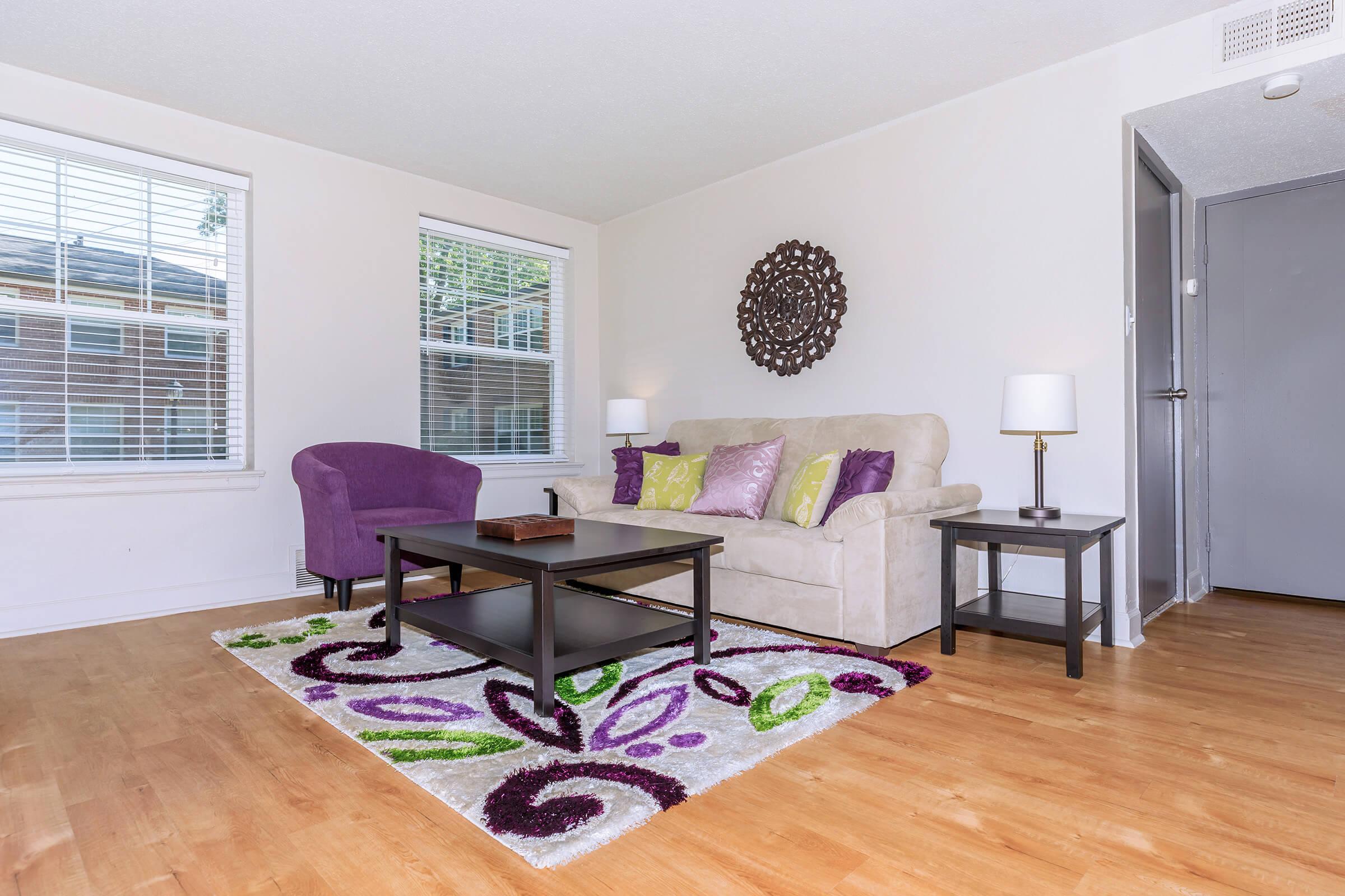 a living room filled with furniture on top of a hard wood floor