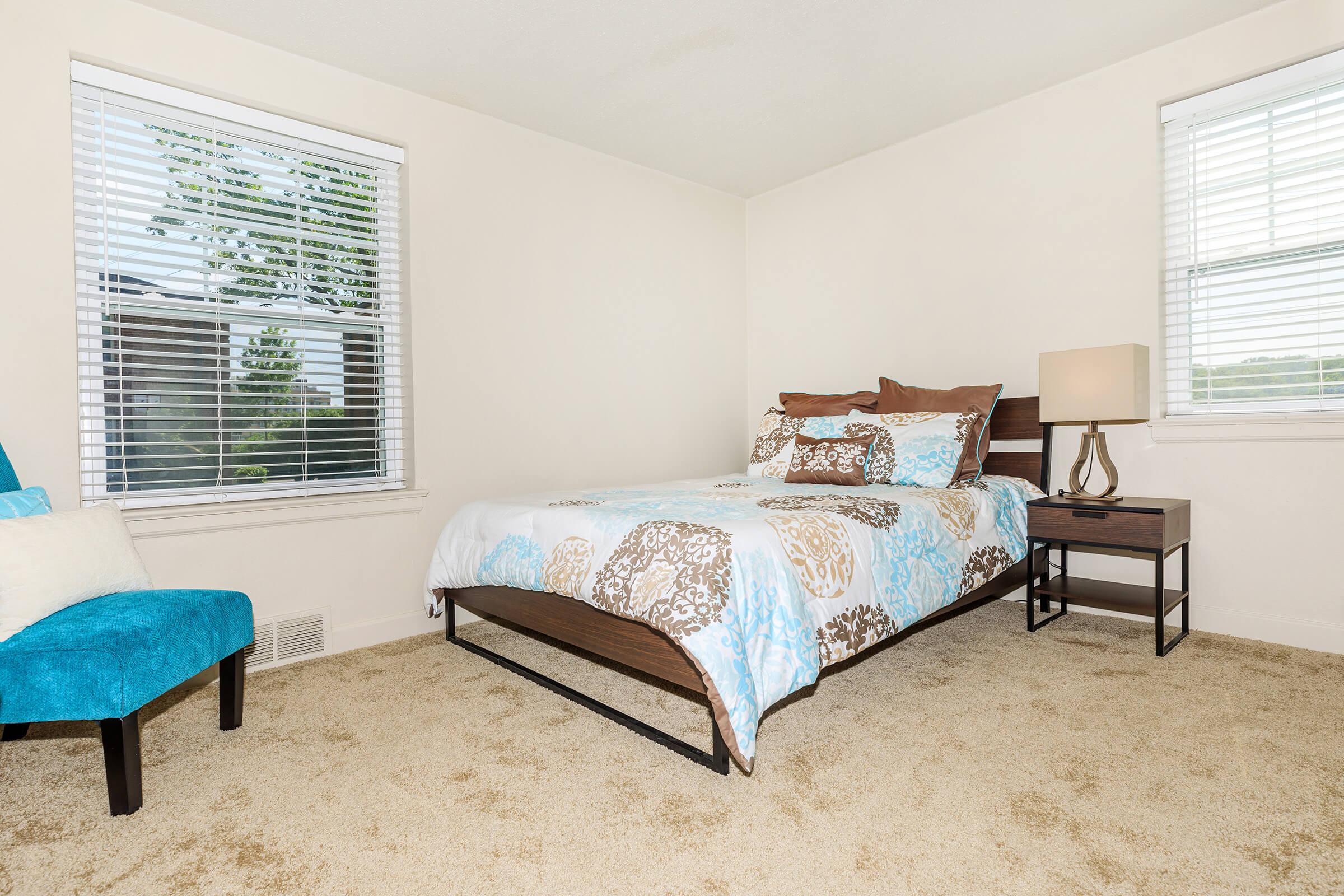 a bedroom with a bed and a chair in a room