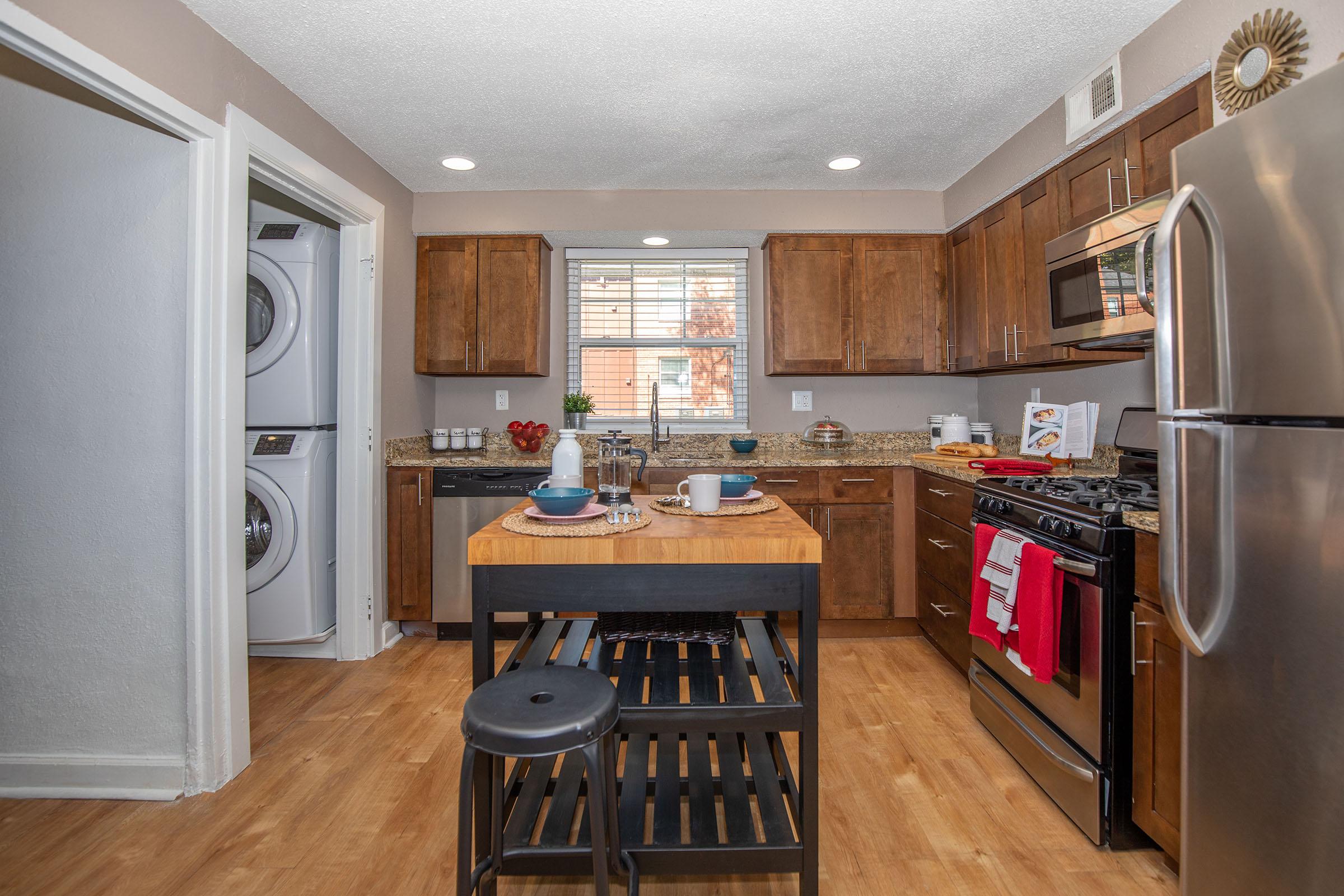 a modern kitchen with stainless steel appliances and wooden cabinets