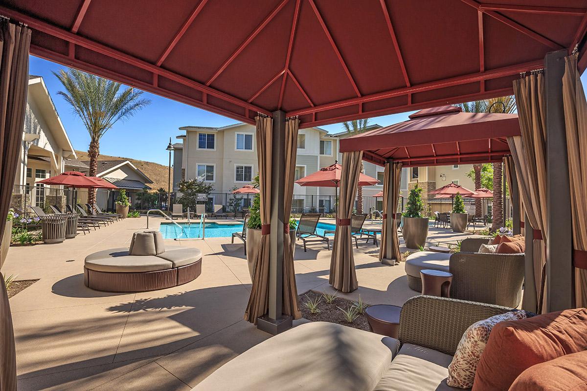 Red cabana's with couches next to the community pool
