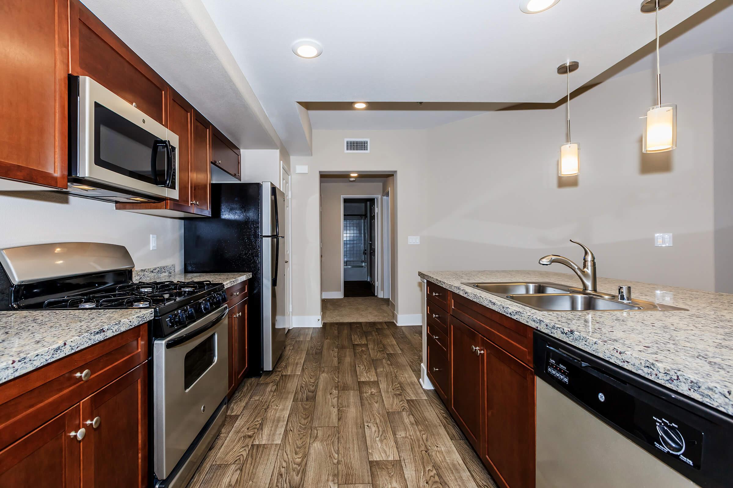 a modern kitchen with stainless steel appliances and wooden cabinets