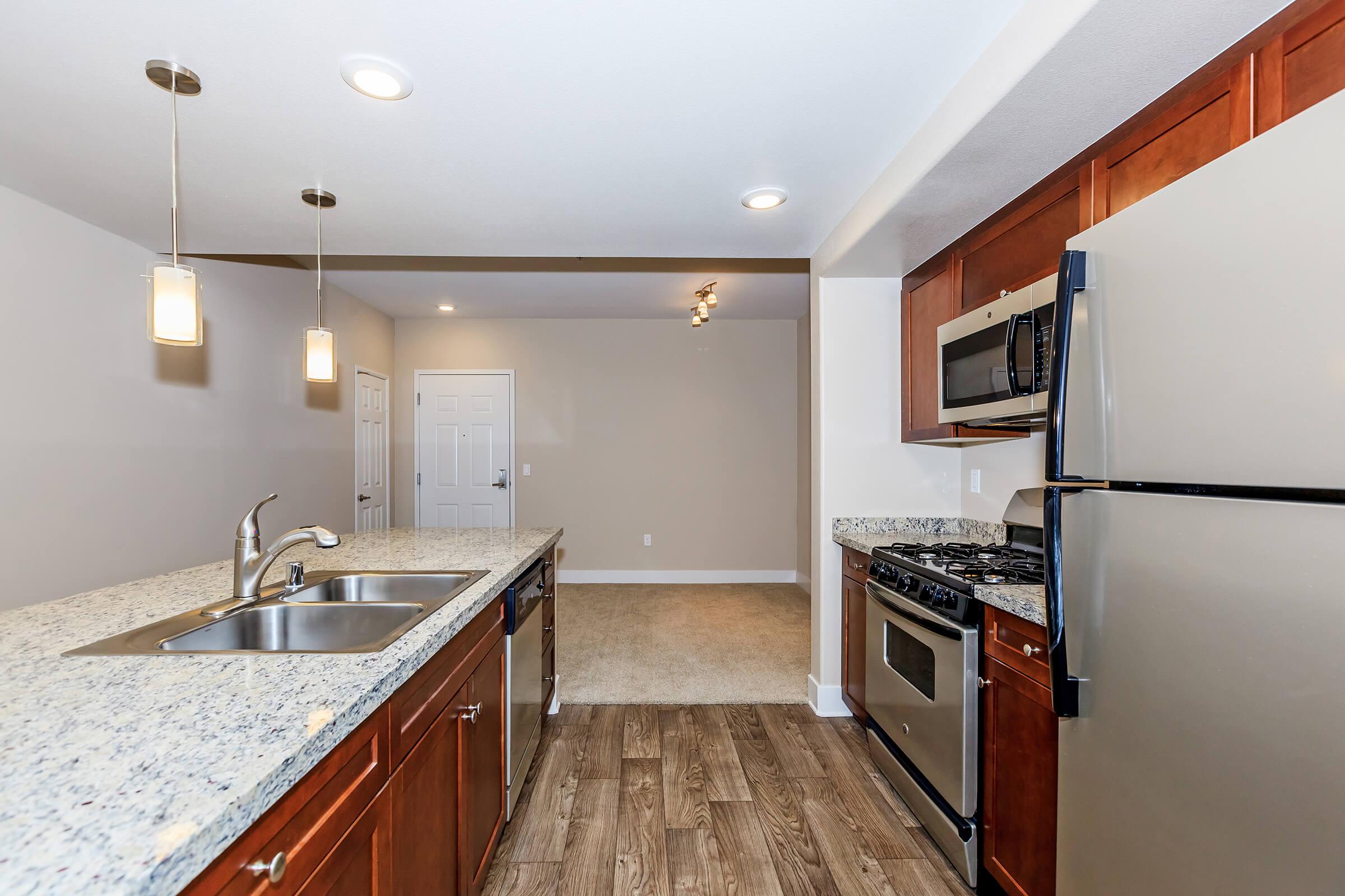 a large kitchen with stainless steel appliances and wooden cabinets