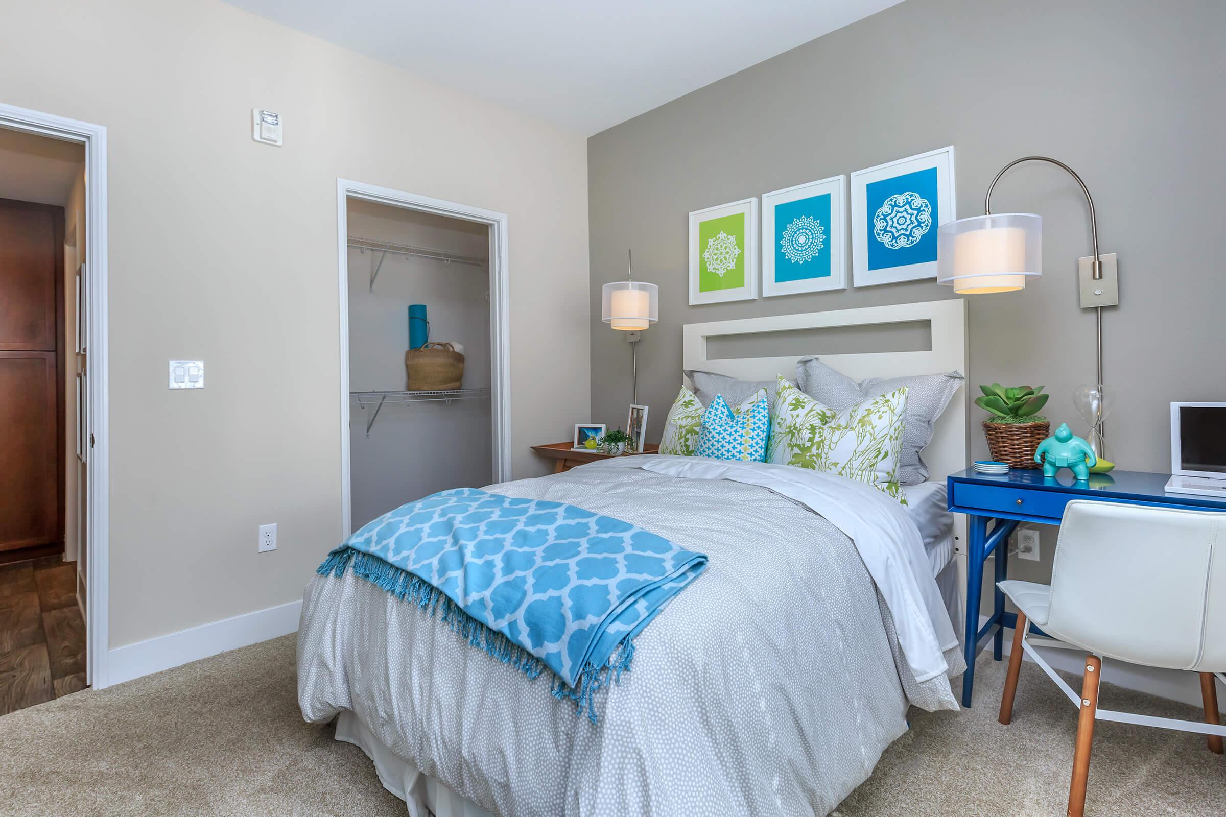 a bedroom with a bed and desk in a room