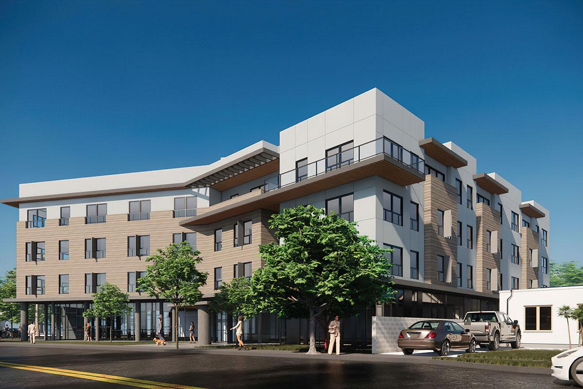 A modern multi-story building with large windows, a mix of wooden and metal siding, and balconies on the upper floors