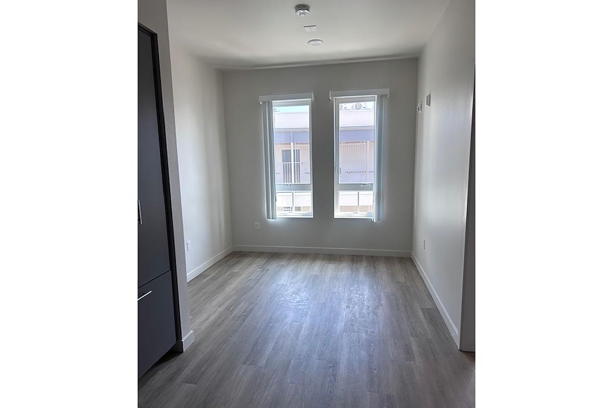 A small, unfurnished room with light-colored walls and a large window letting in natural light.