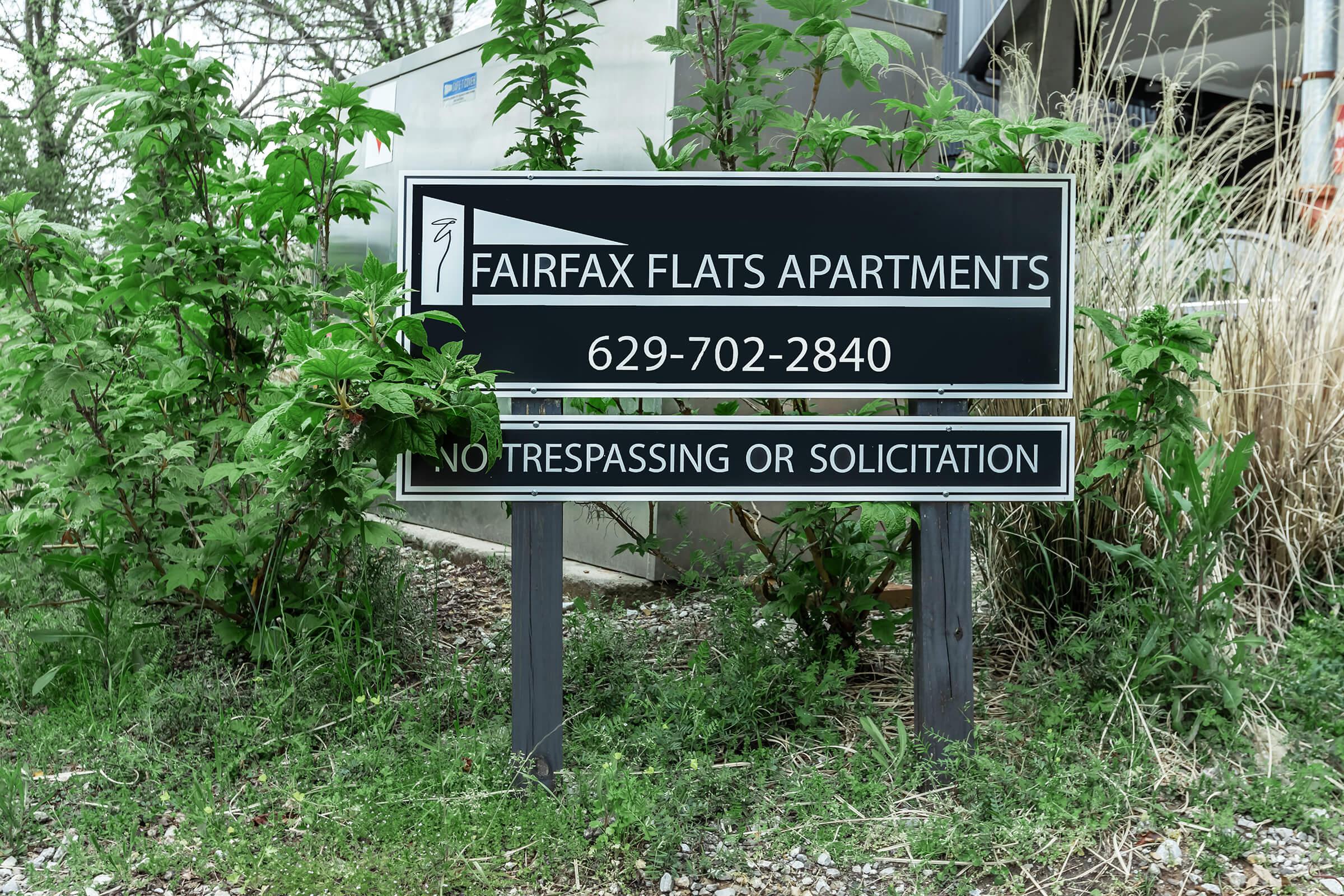 a street sign in front of a tree