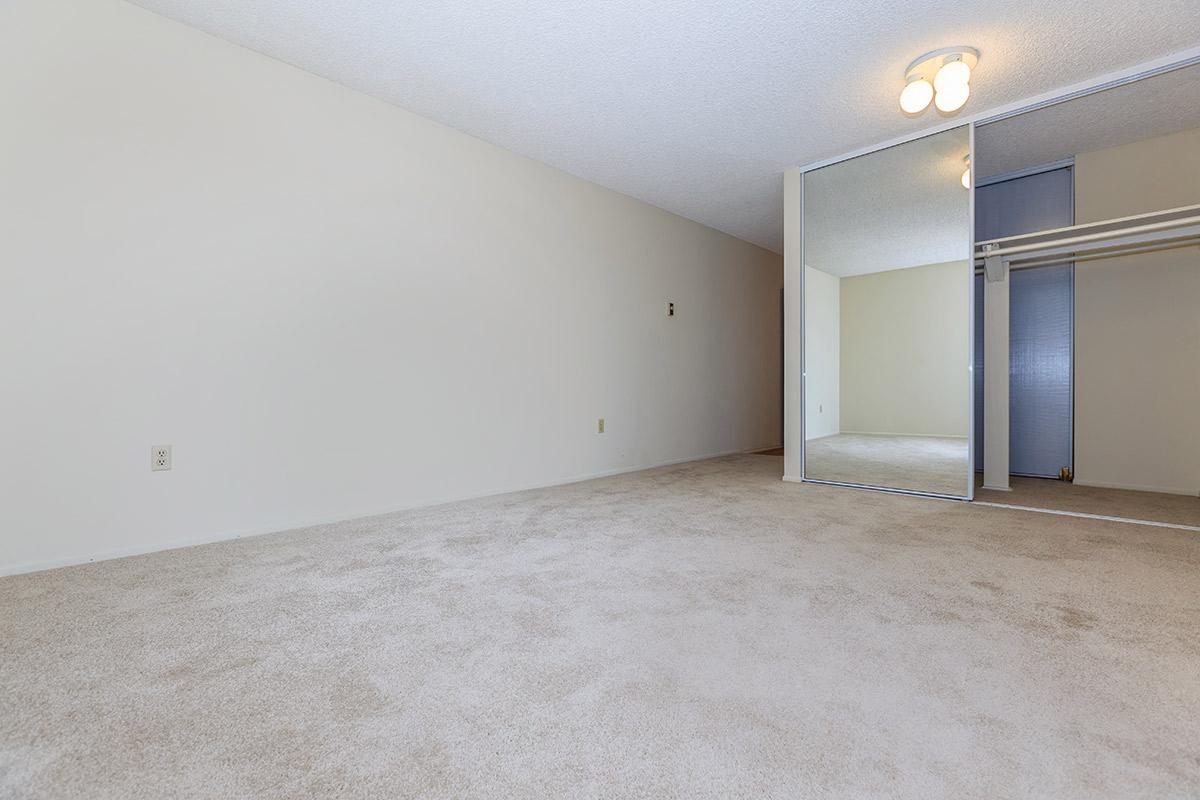 Unfurnished bedroom with sliding mirror glass closet doors